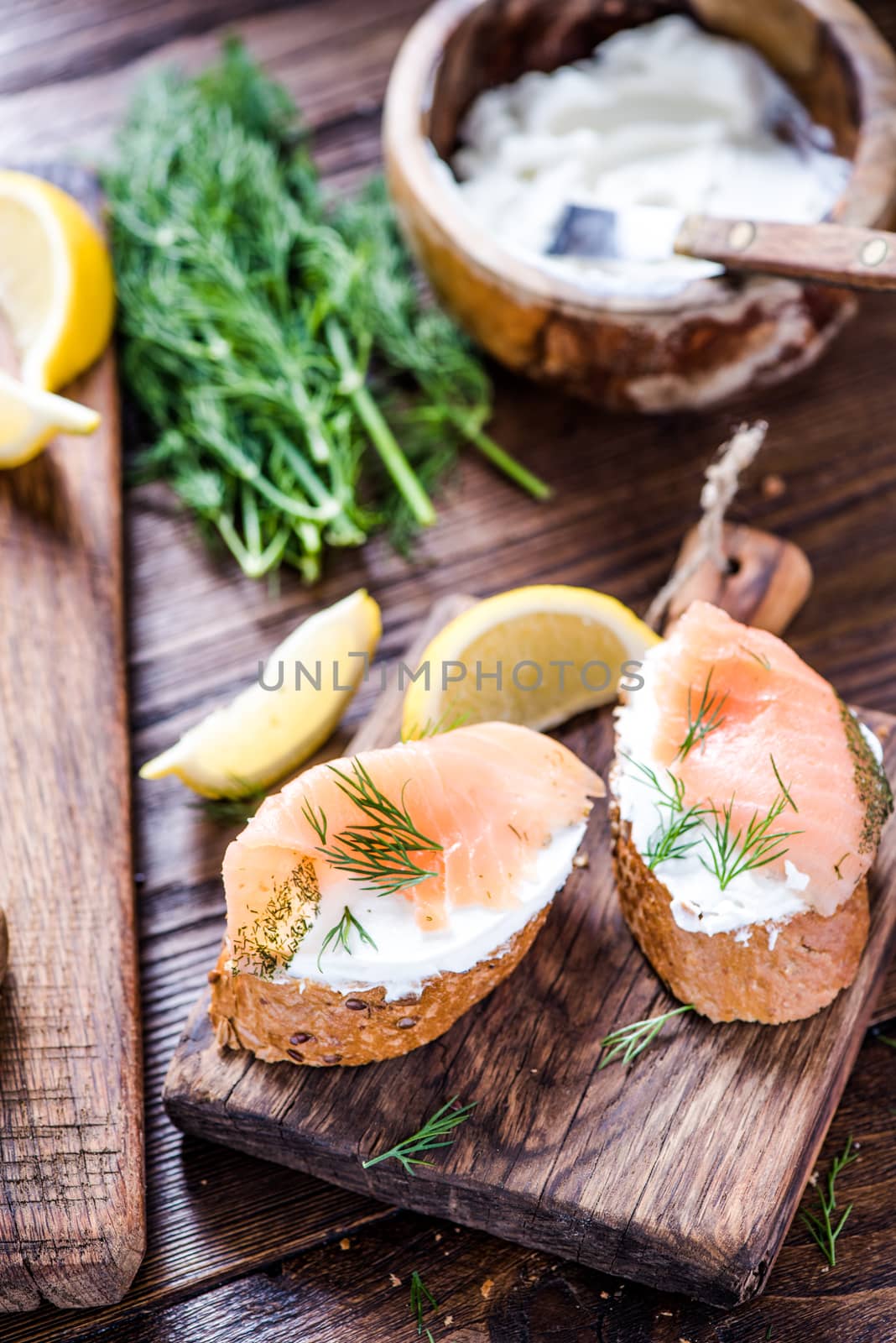 Fresh bread cottage cheese and smoked salmon with dill on wooden serving board