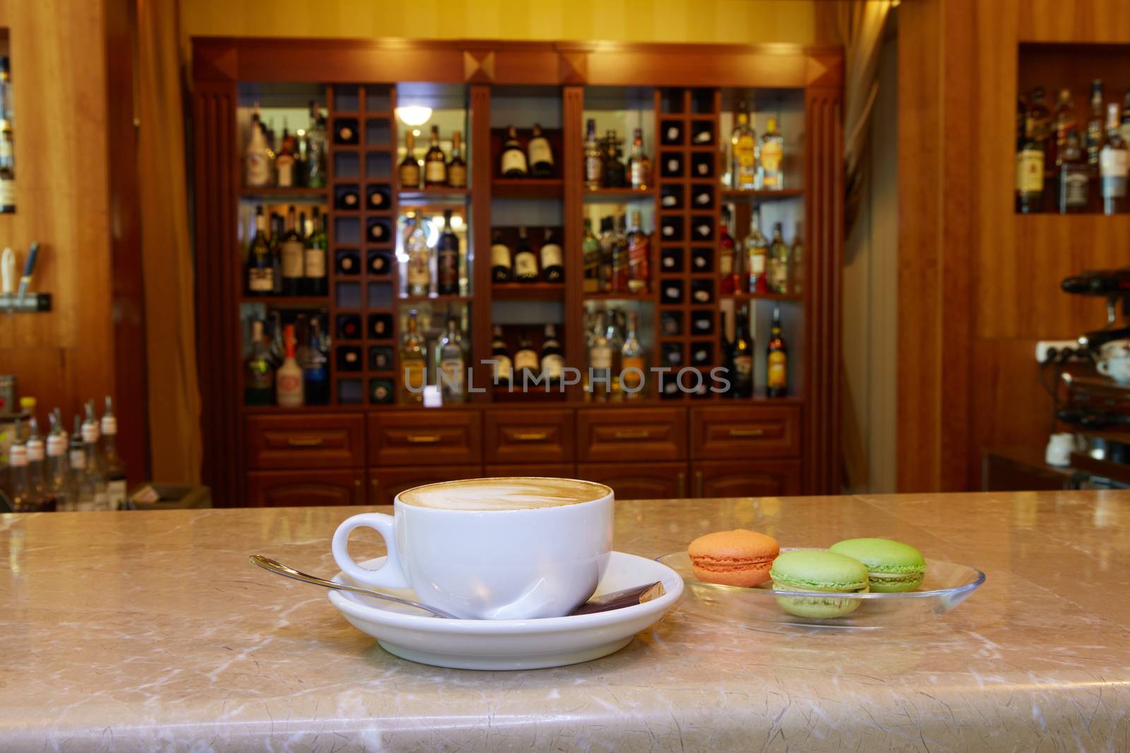 Cup of coffee and coffee break on wood table and macarons and cold water background and nature background and blur background in coffee shop