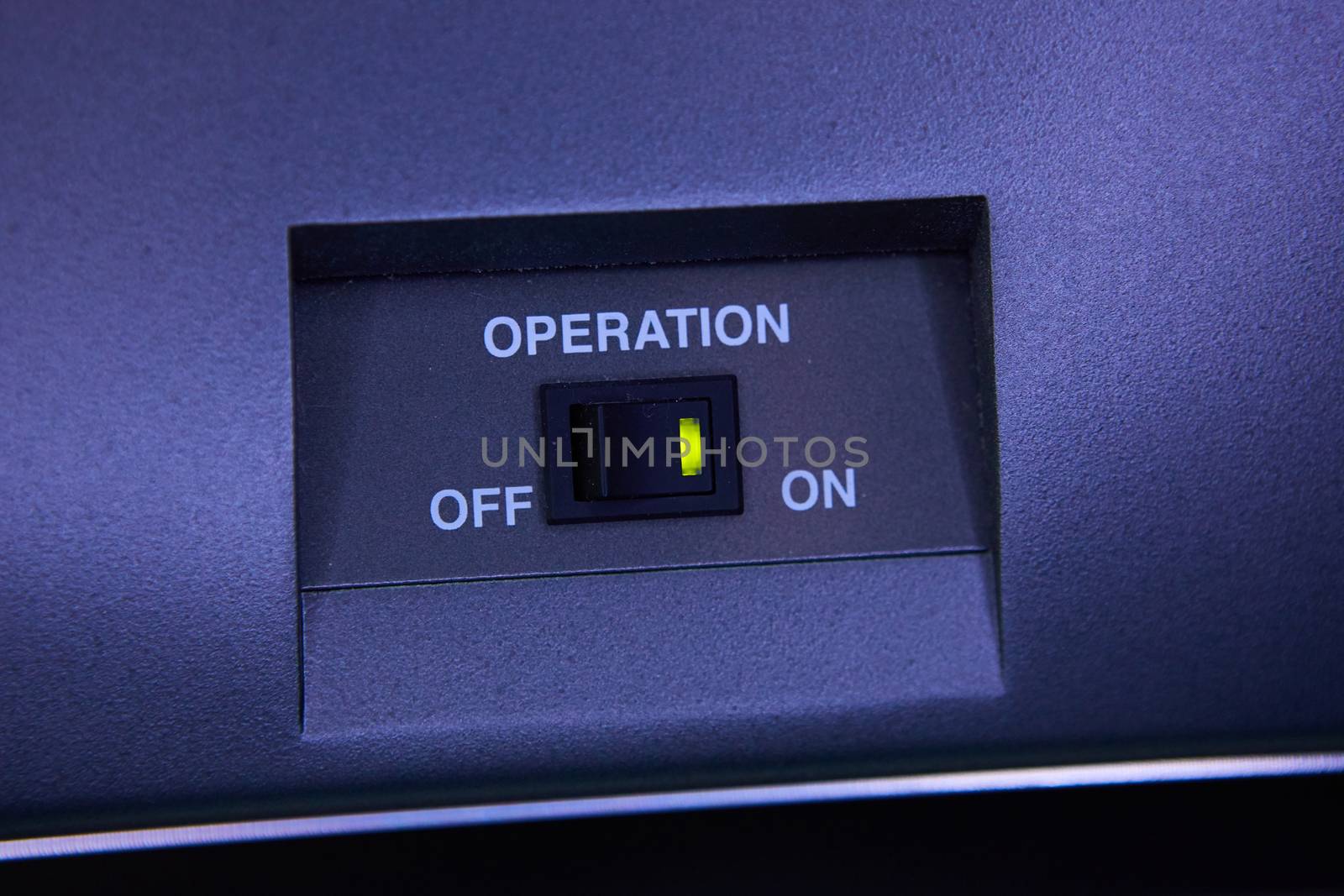 Black toggle switch on blue surface - on off.