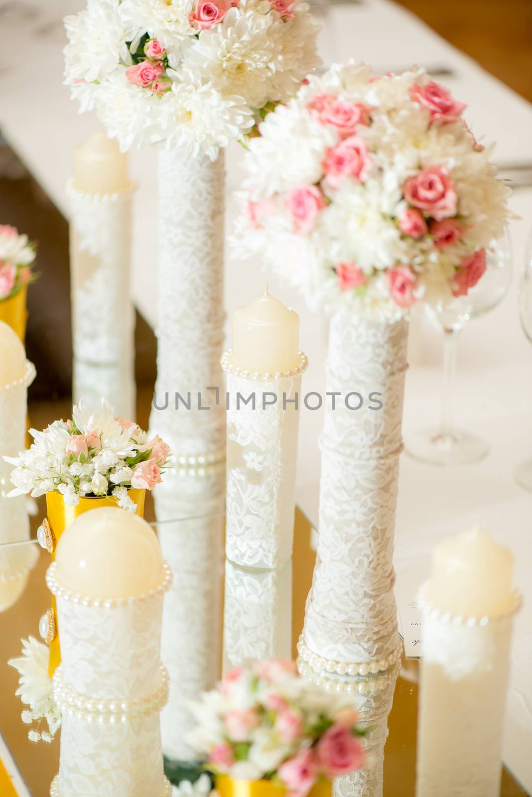 Wedding table decoration with flowers, candle and glassware