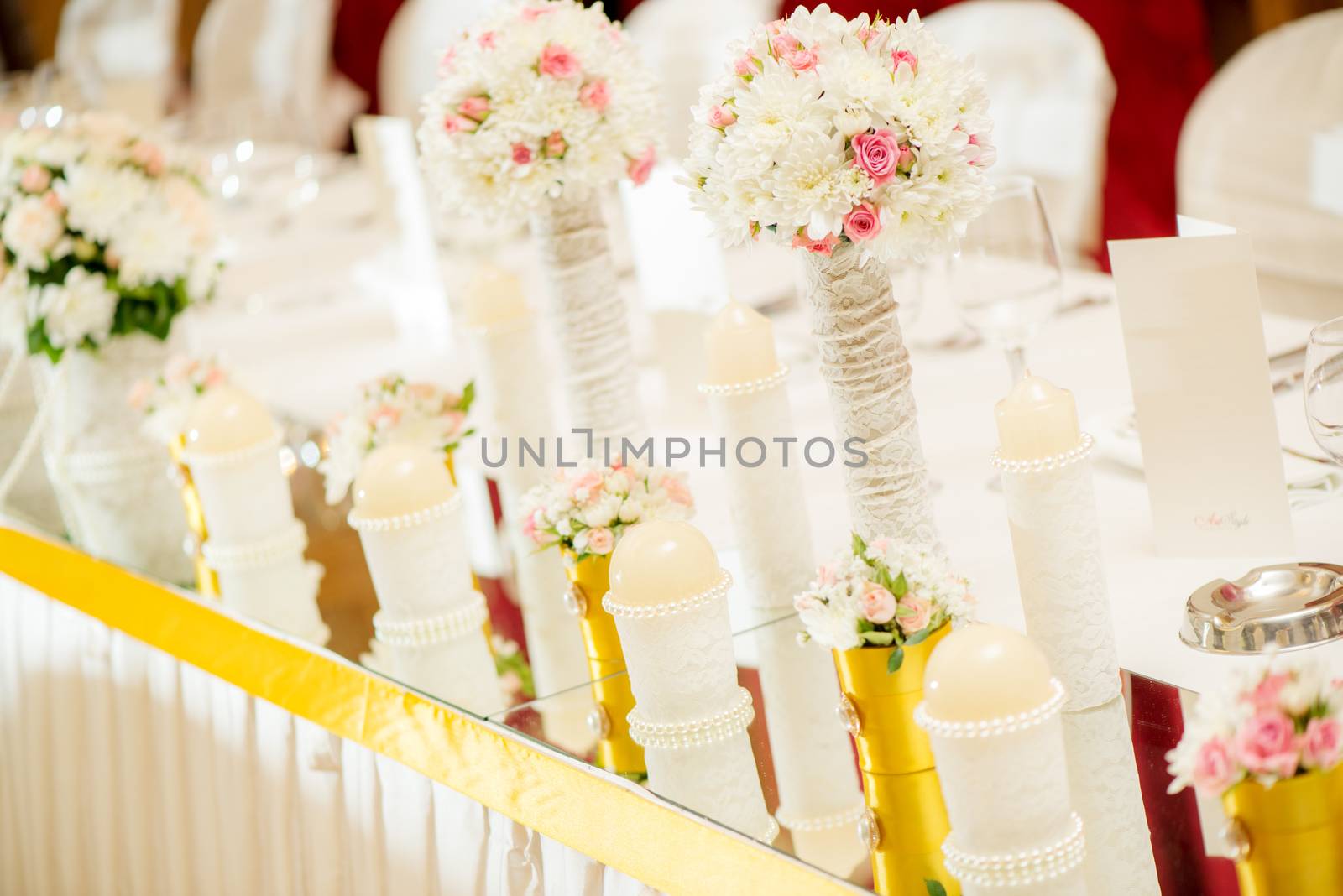 Wedding table decoration with candle, flowers and glassware