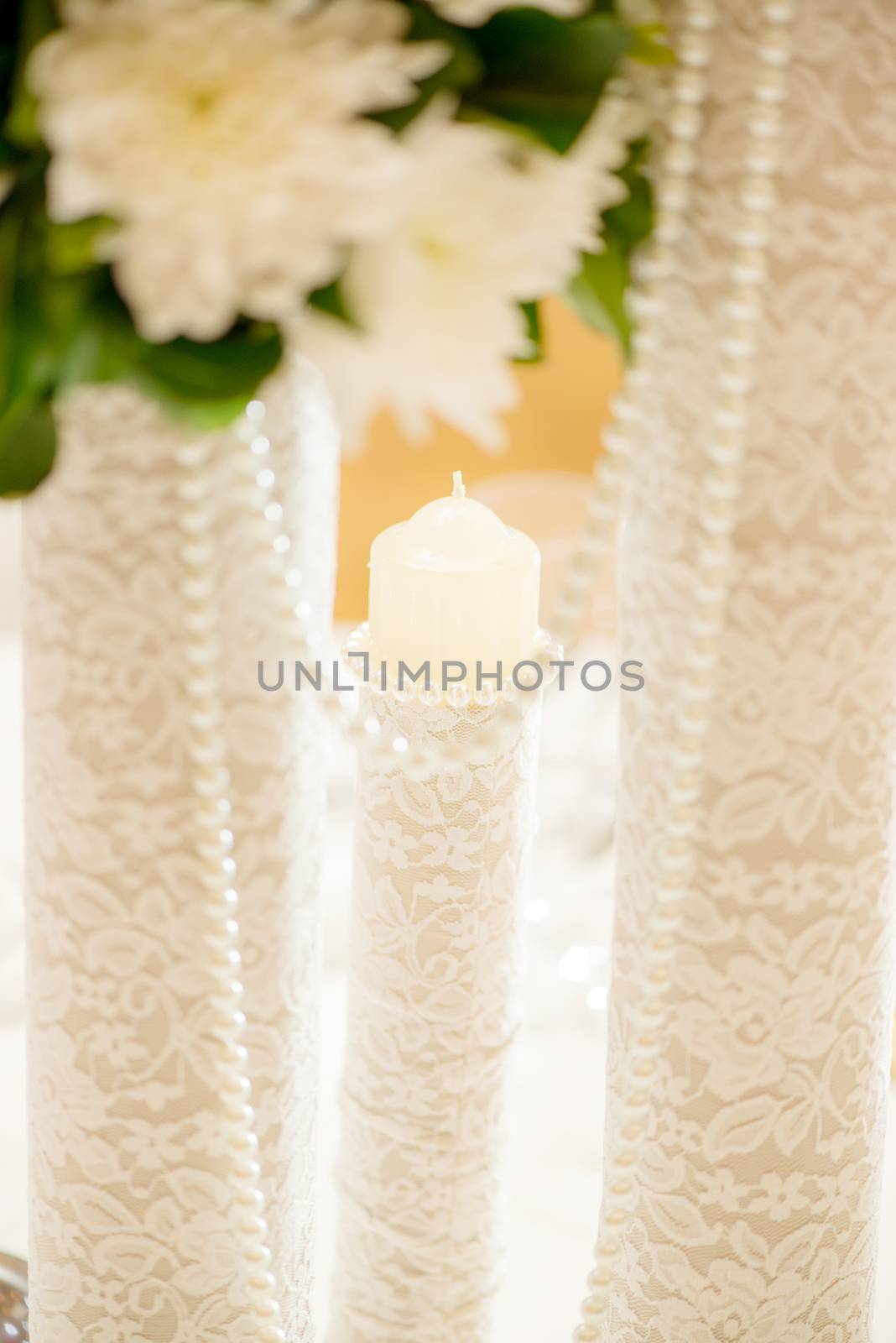 Wedding table decoration with candle, pearls and lace