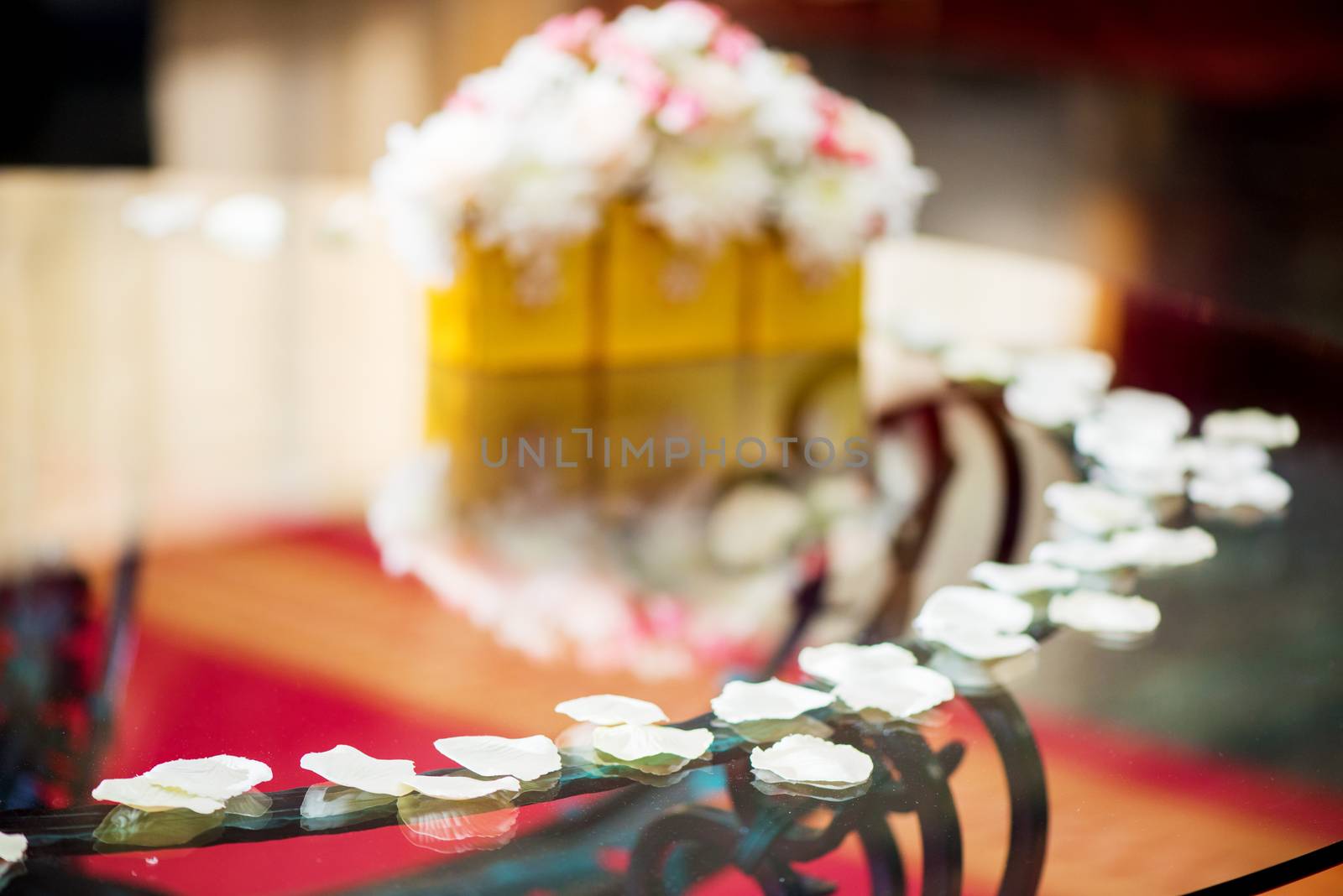 Wedding table decoration with white petals and flowers. Selective focus. 