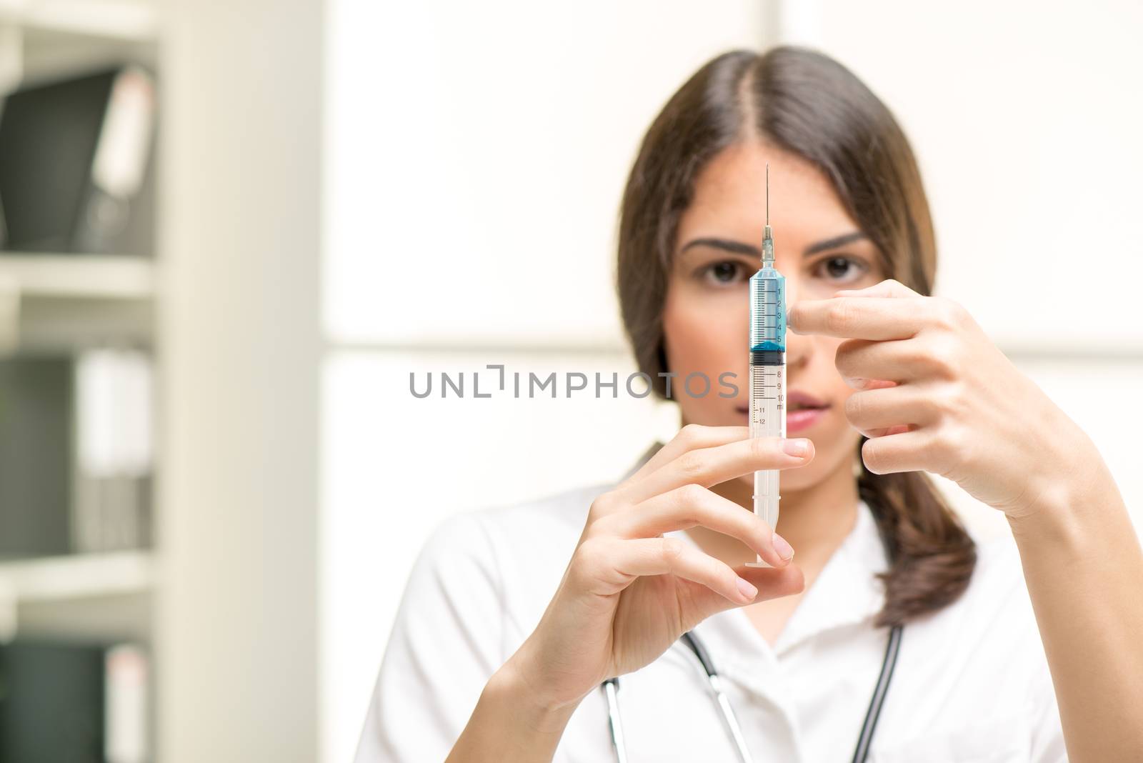 Pretty young nurse preparing an injection of Anesthesia.