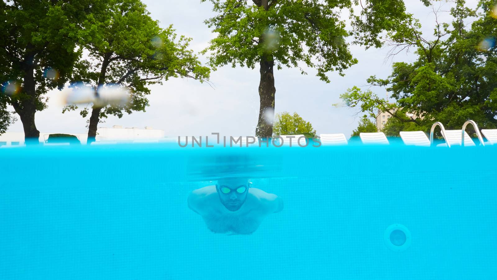 Male Swimmer Under Water in hotel Pool
