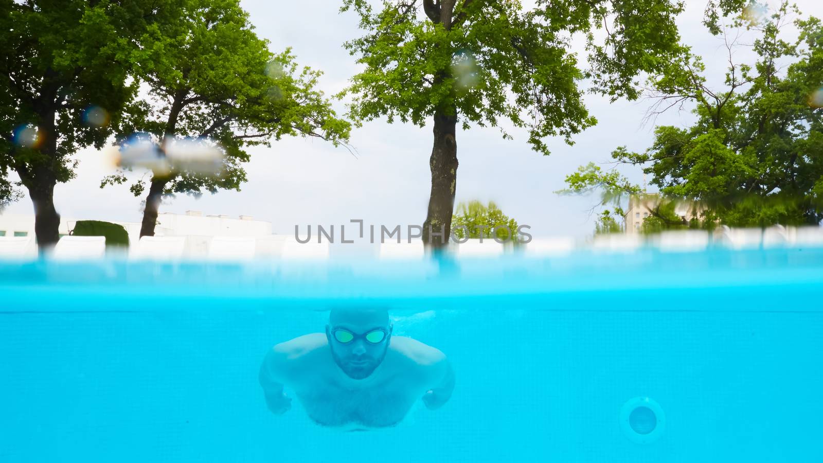 Male Swimmer Under Water in hotel Pool