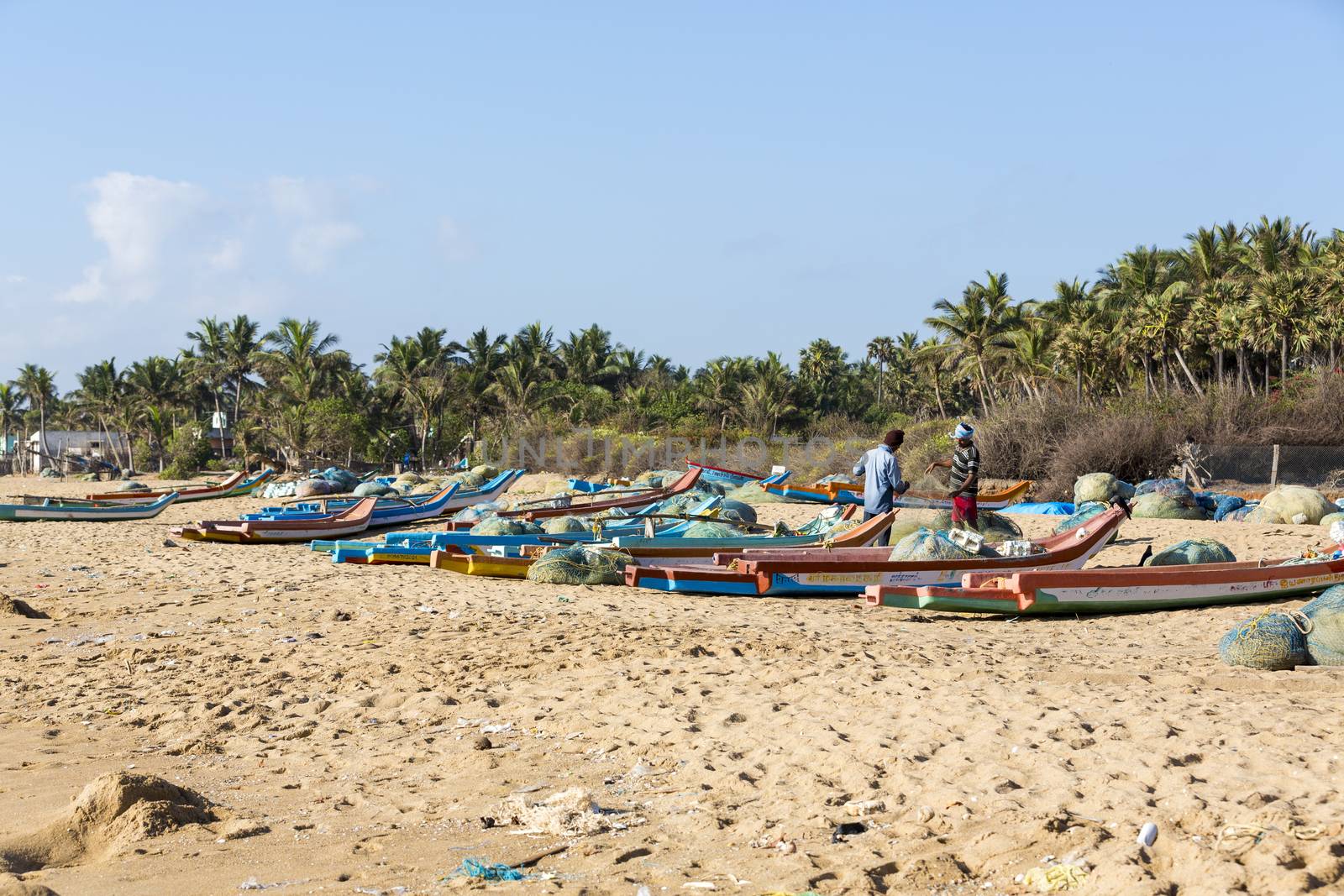 Pondichery, Tamil Nadu, India - February 27, 2014 : Traditional fishermen on beach, on sea, on sand. Long boats, Hard work poor people