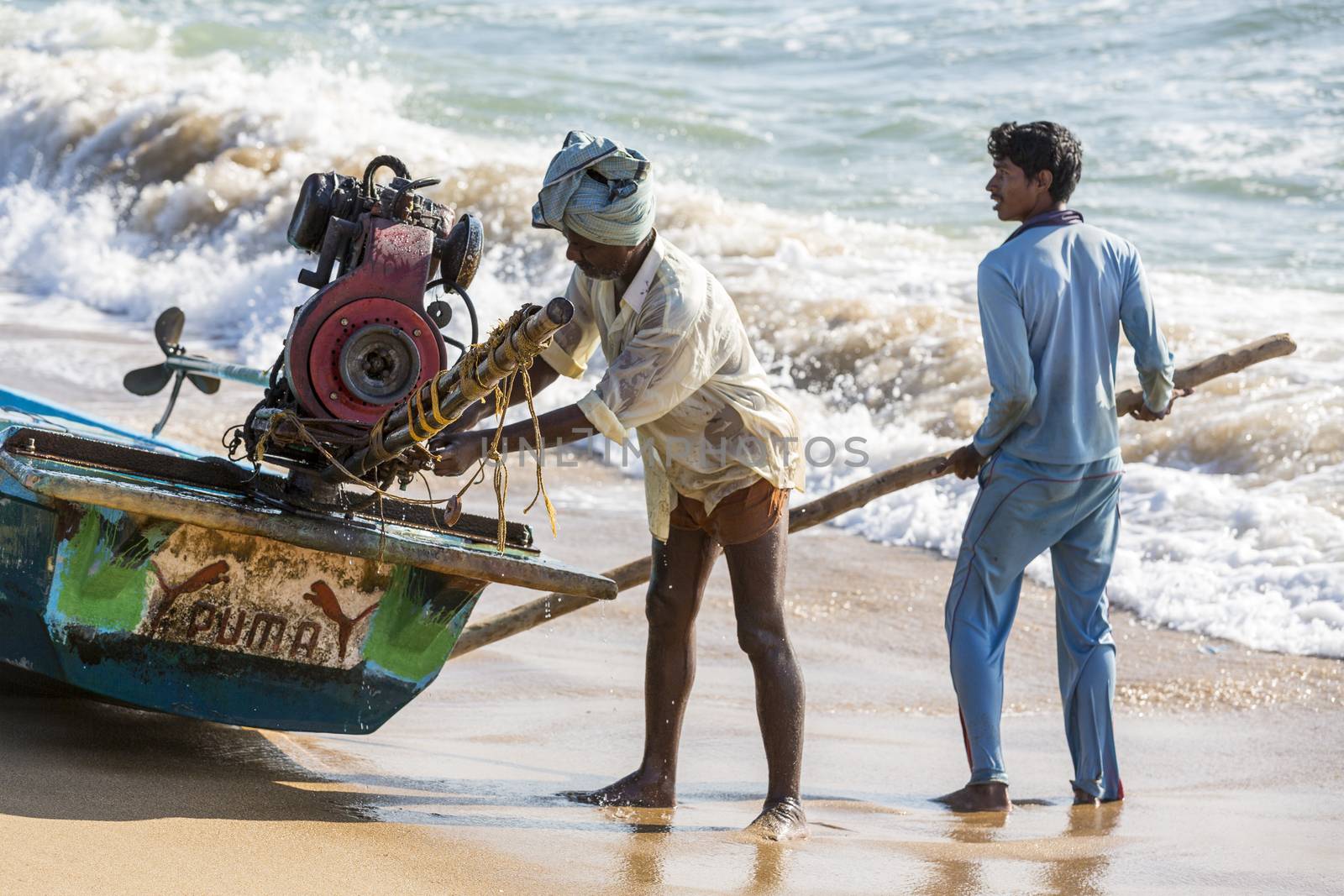 Pondichery, Tamil Nadu, India - February 27, 2014 : Traditional fishermen on beach, on sea, on sand. Long boats, Hard work poor people