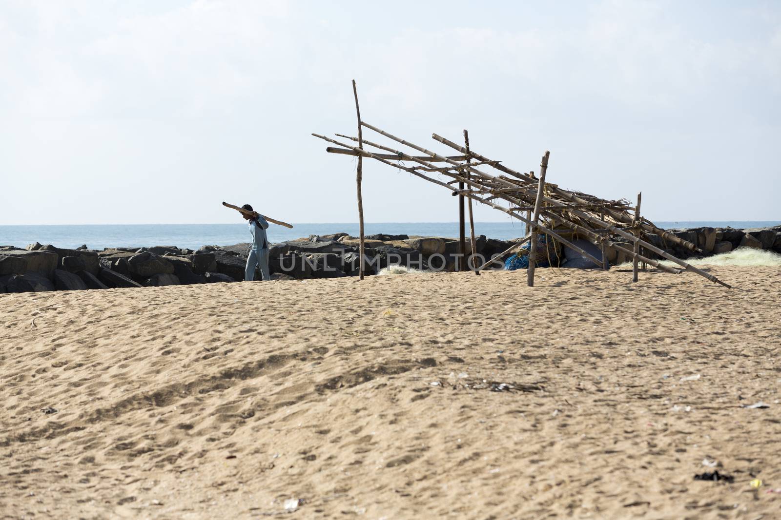 Pondichery, Tamil Nadu, India - February 27, 2014 : Traditional fishermen on beach, on sea, on sand. Long boats, Hard work poor people