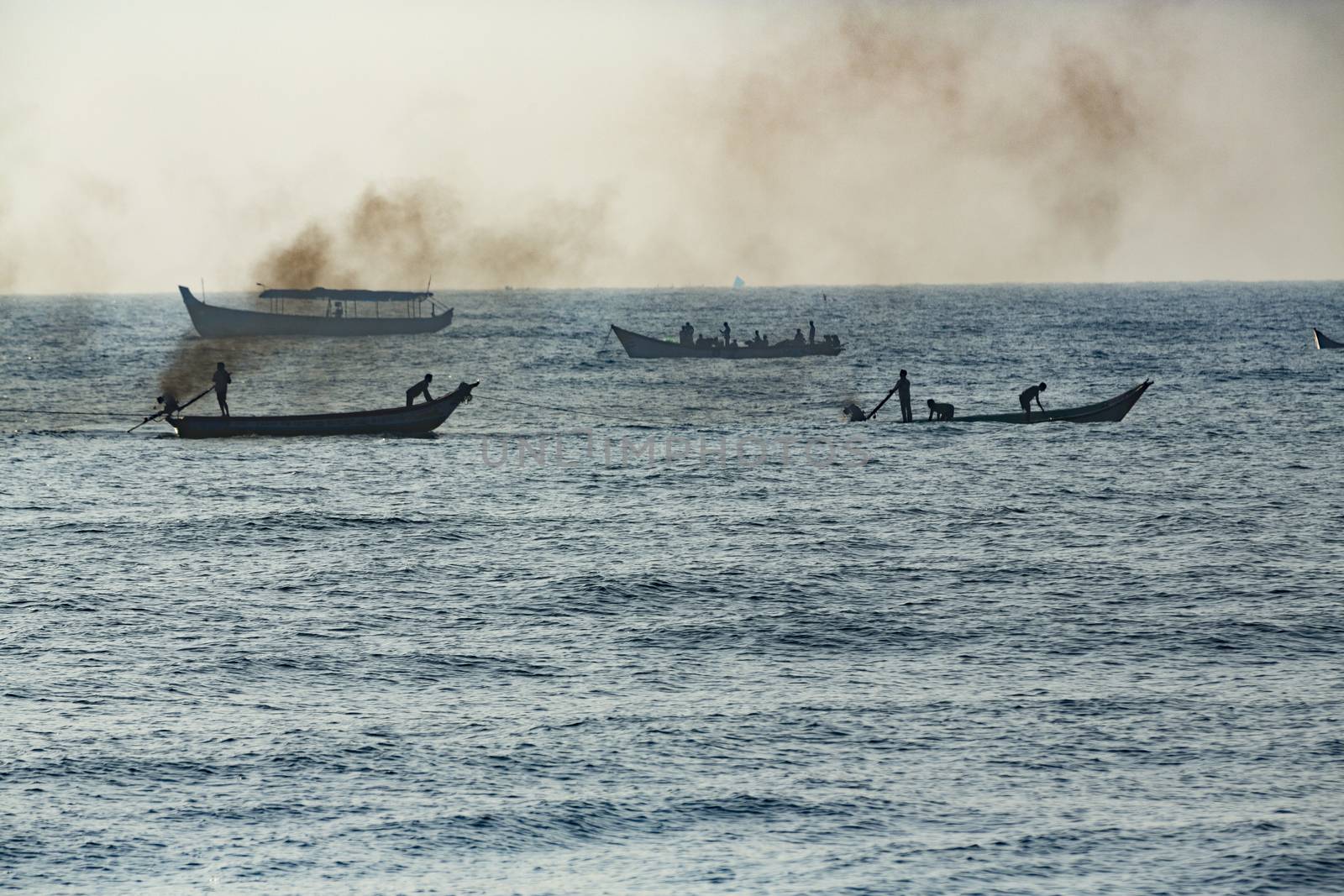 Pondichery, Tamil Nadu, India - February 27, 2014 : Traditional fishermen on beach, on sea, on sand. Long boats, Hard work poor people