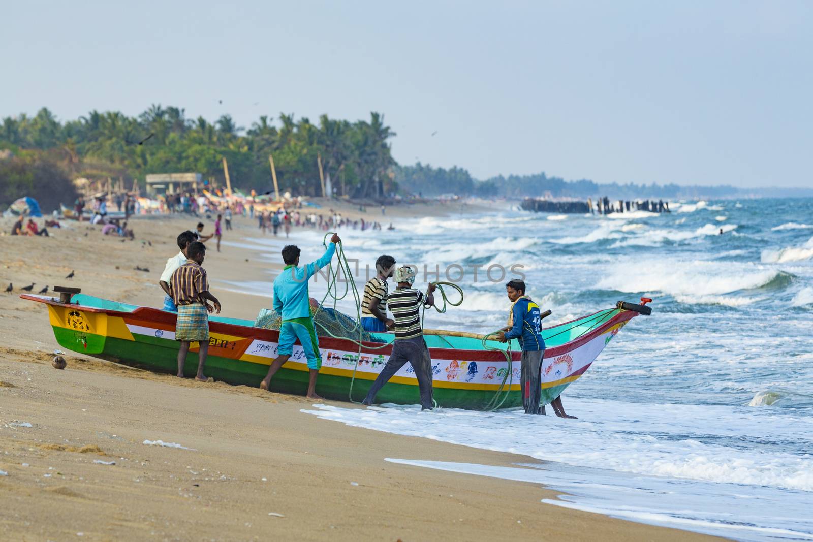 Pondichery, Tamil Nadu, India - February 27, 2014 : Traditional fishermen on beach, on sea, on sand. Long boats, Hard work poor people