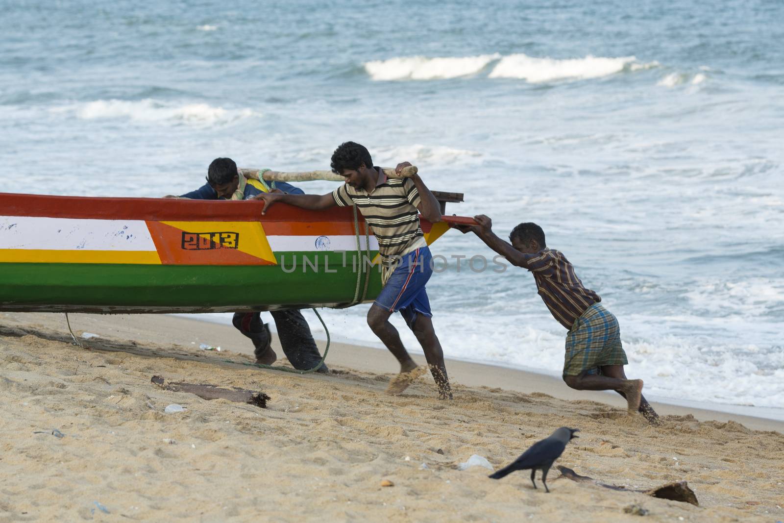 Pondichery, Tamil Nadu, India - February 27, 2014 : Traditional fishermen on beach, on sea, on sand. Long boats, Hard work poor people