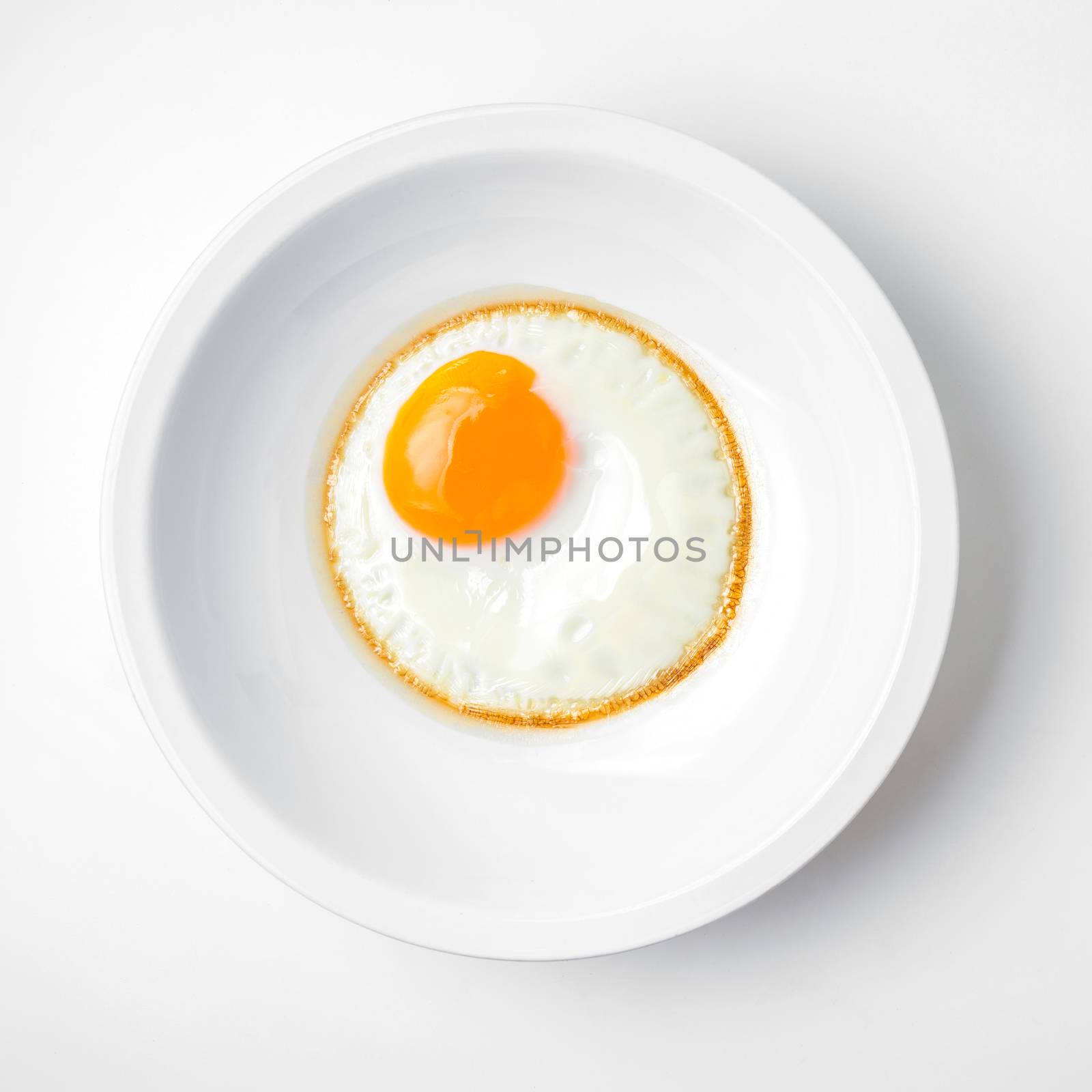 fried egg on white plate isolated on white background