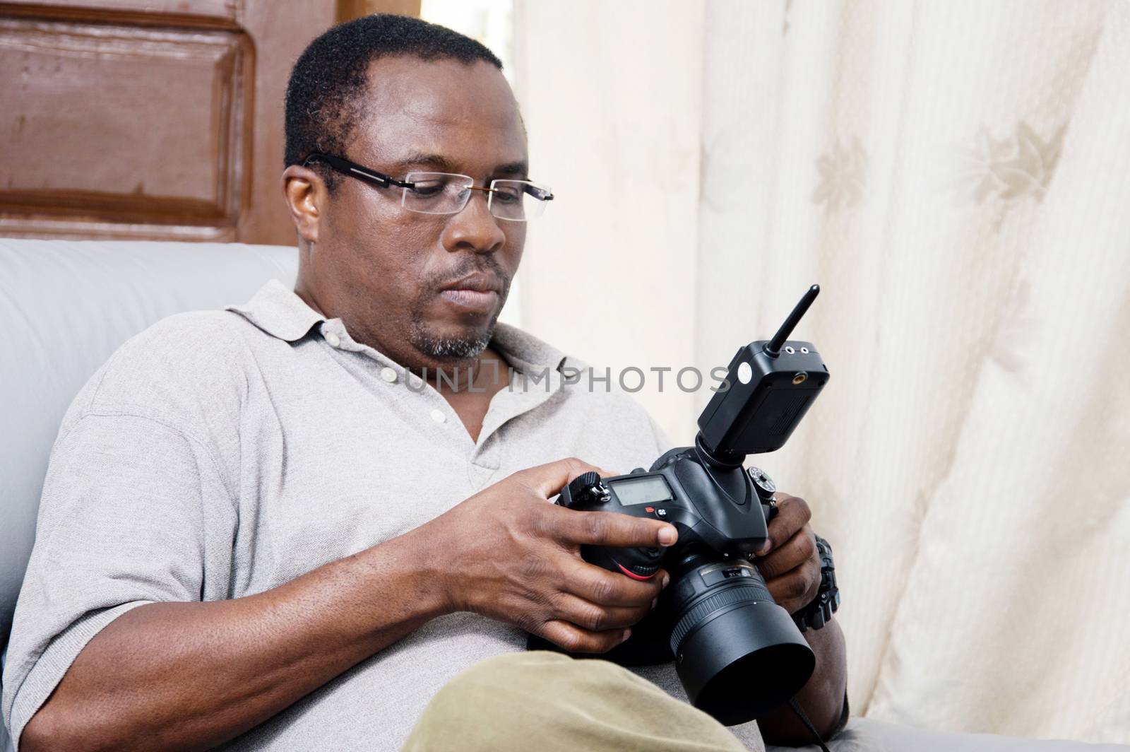 After his photo shoot; this photographer looks at his pictures to appreciate.
