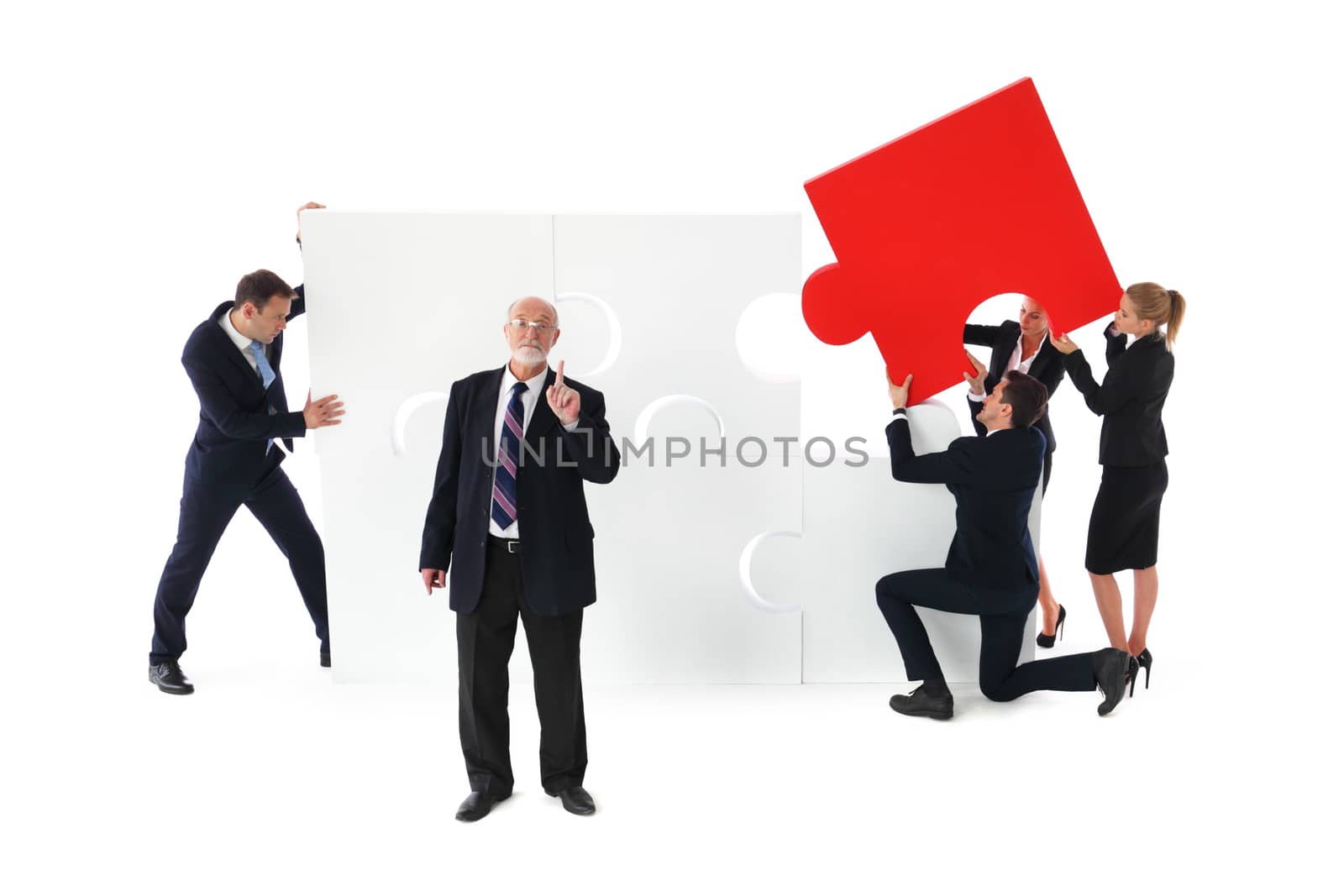 Group of business people assembling jigsaw puzzle isolated on white background