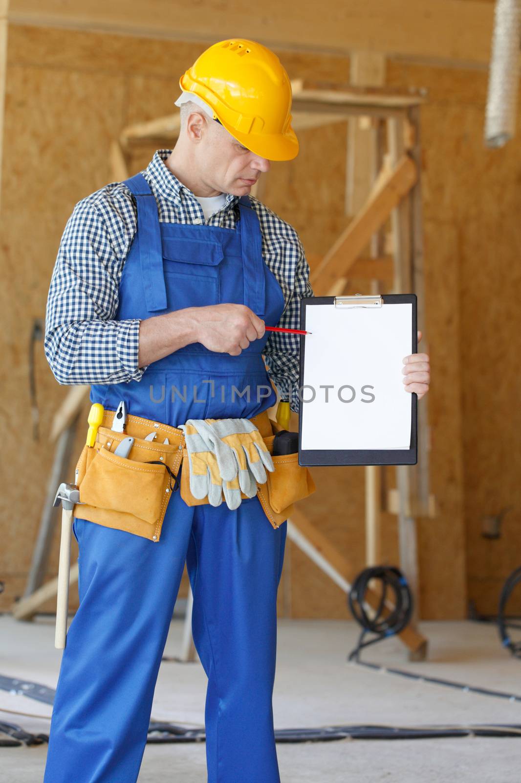Portrait of foreman pointing at white folder plate