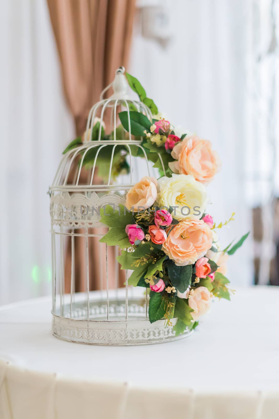 White cage with flowers as decoration on wedding day
