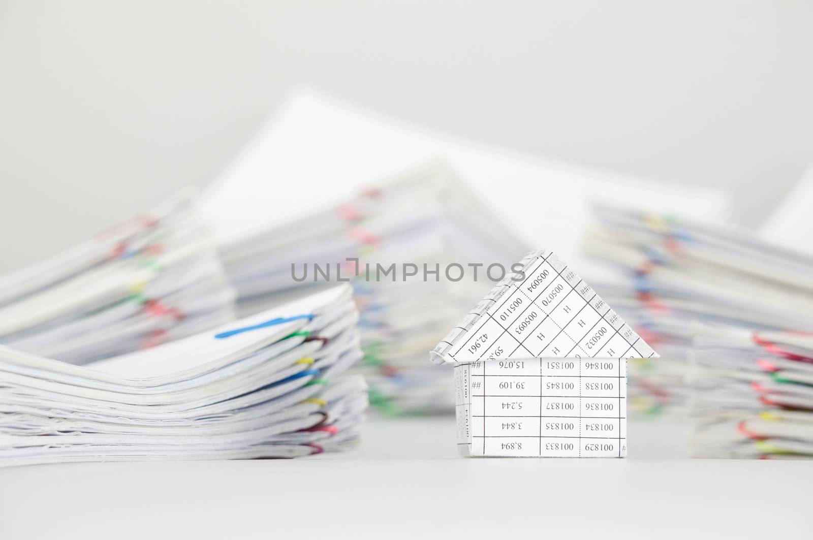 Close up house have blur pile overload paperwork of report and receipt with colorful paperclip place as background.