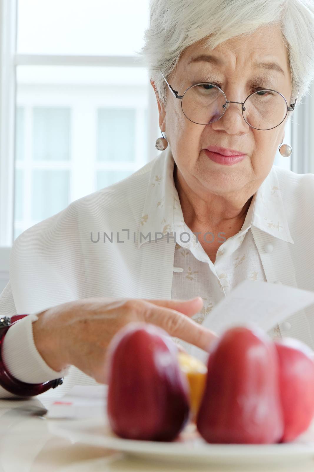 Senior woman reading a book at home