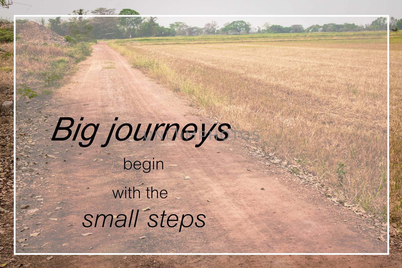 Word  Big journeys begin with the small steps.Inspirational motivational quote on a countryside road background