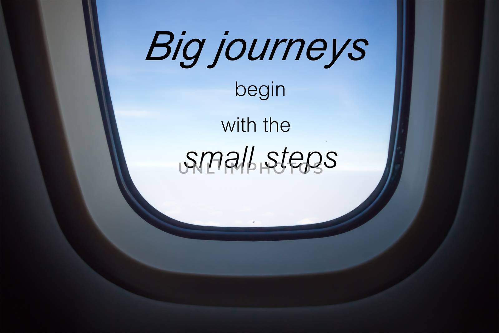 Word  Big journeys begin with the small steps.Inspirational motivational quote on plane window background by phatpc