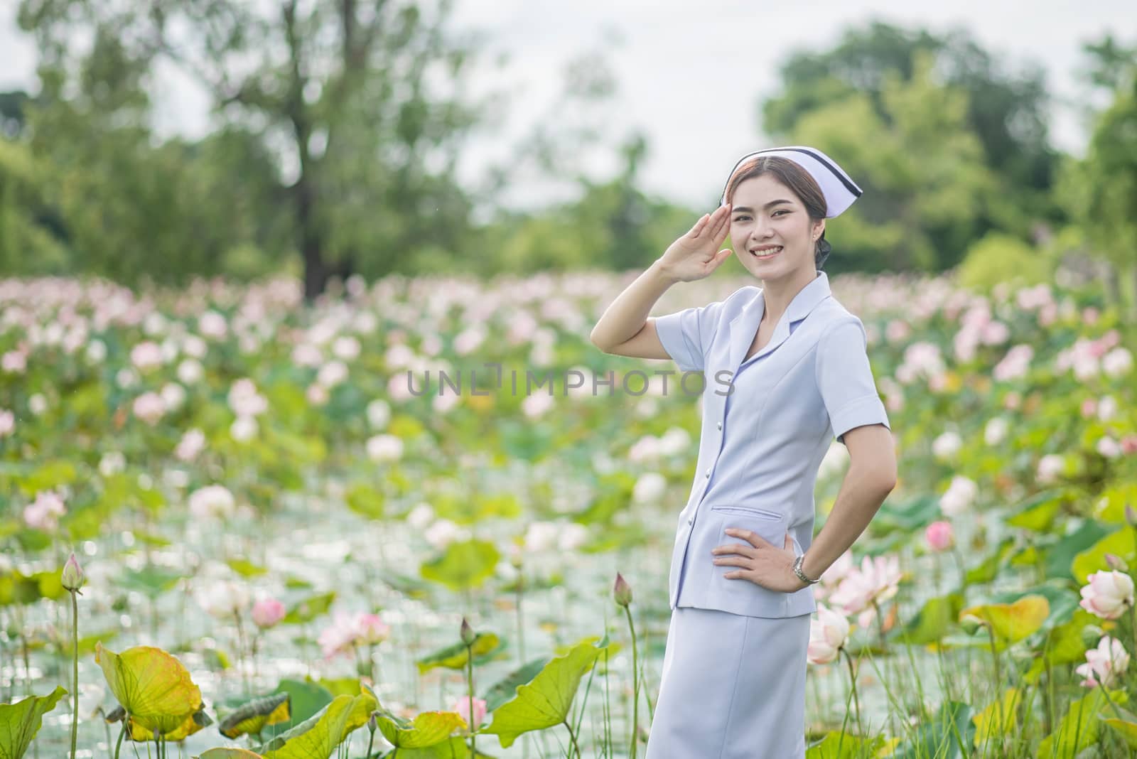 Portrait of a Beautiful Young Woman Asian Nurse in the Lotus Park