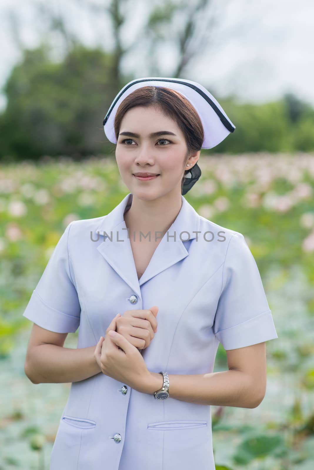 Portrait of a Beautiful Young Woman Asian Nurse in the Lotus Park