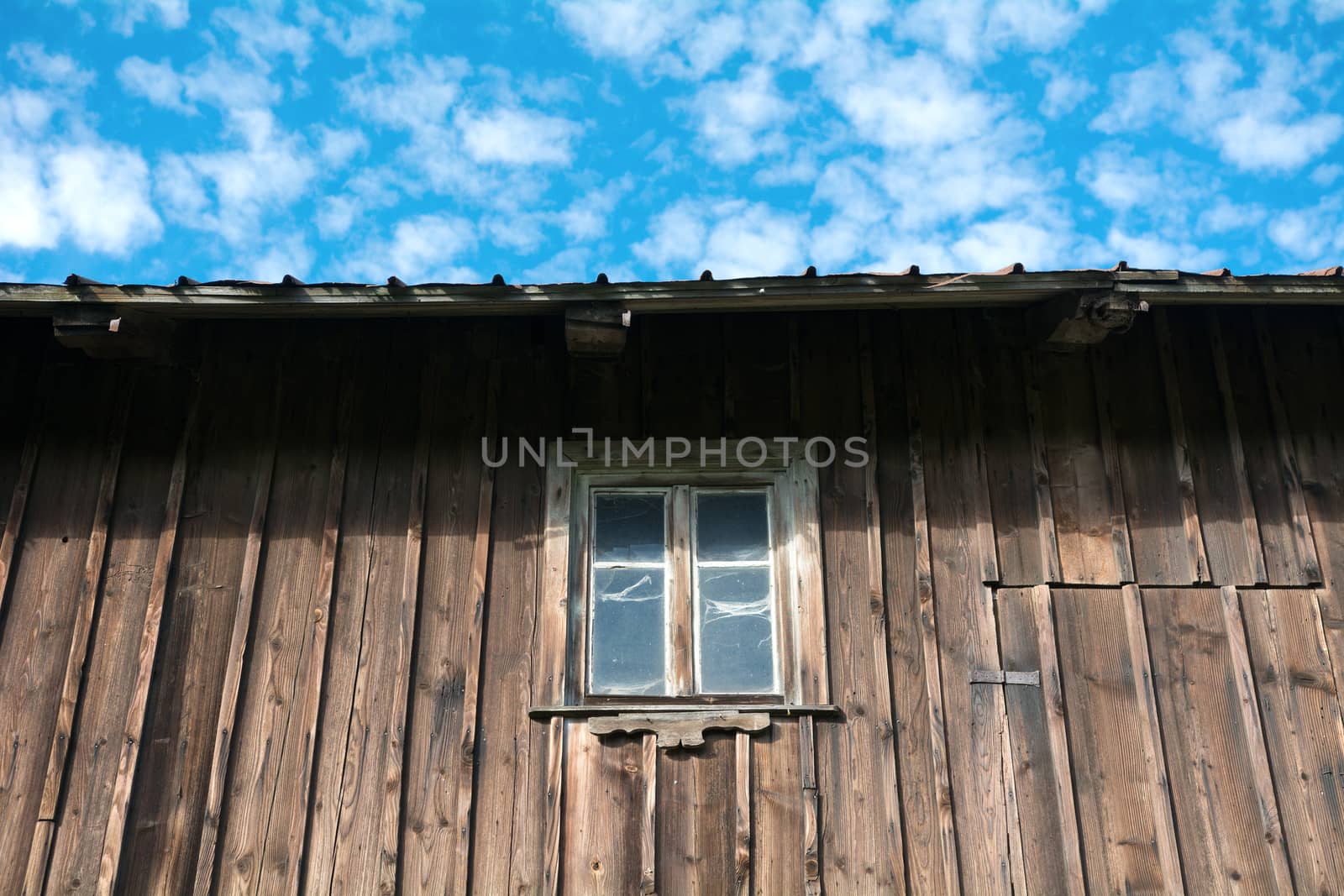 A window in a wooden wall with sky background