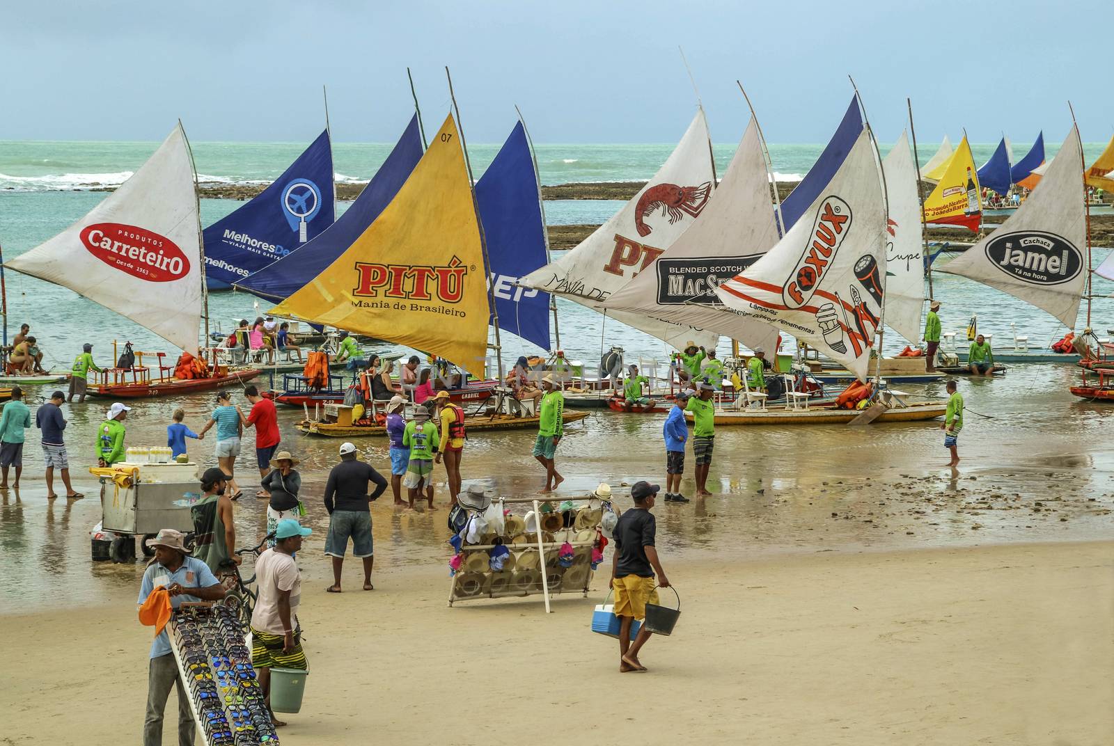 Pernambuco, Brazil July 6, 2016: An unidentified group of people in Chicken Beach with typical sail boats in Ipojuca City, northeast Brazil
