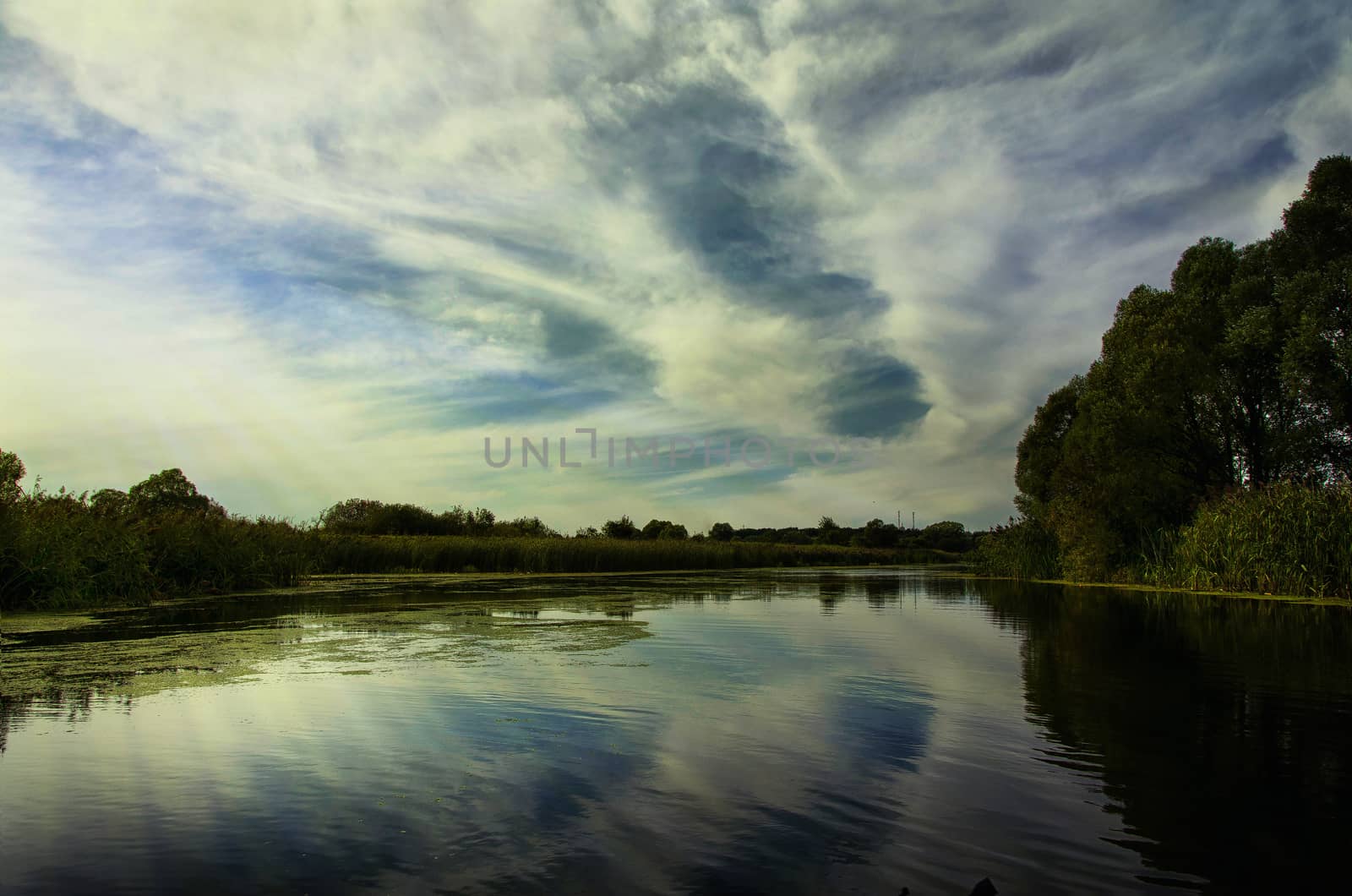 Summer landscape with low clouds and the river on a Sunny day