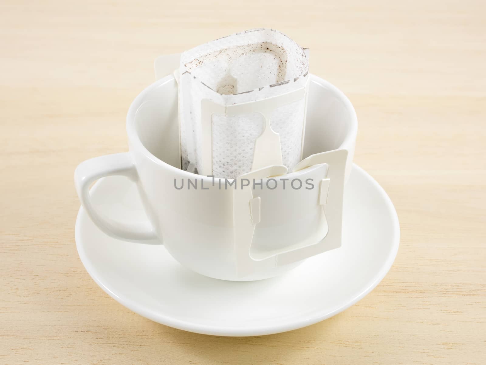 The instant freshly brewed coffee drip bag on white coffee cup.