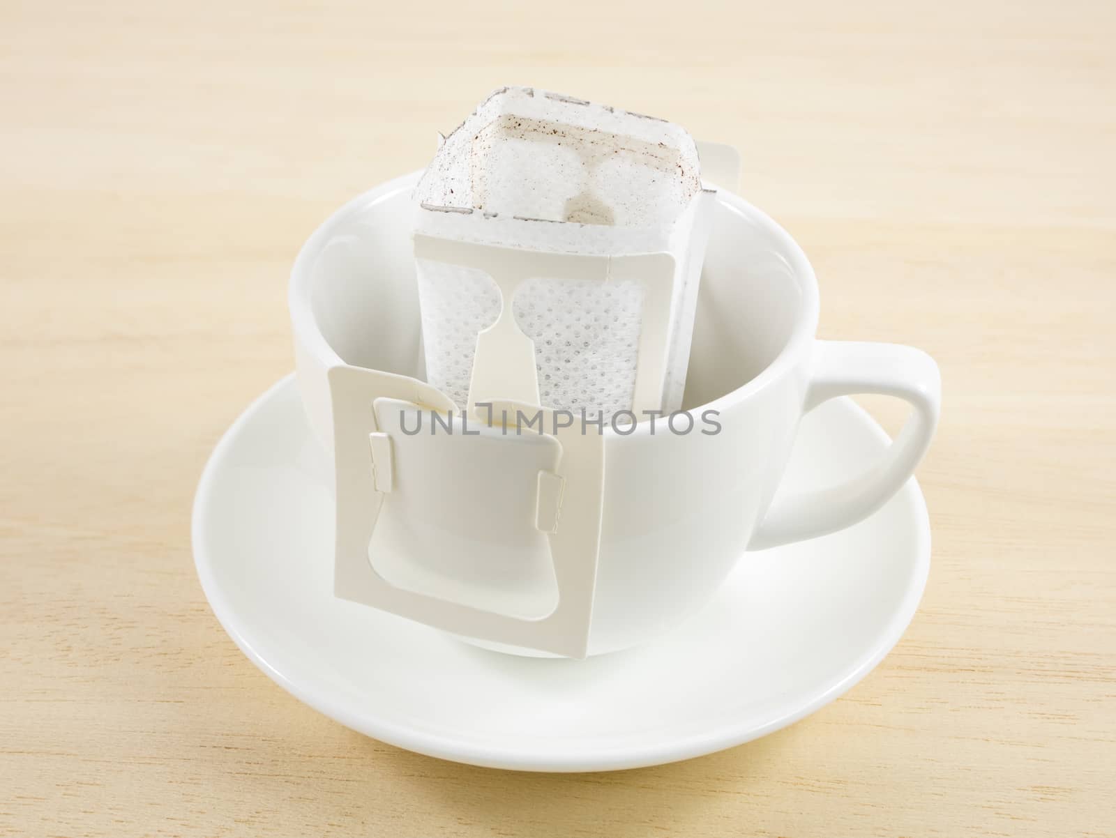 The instant freshly brewed coffee drip bag on white coffee cup.