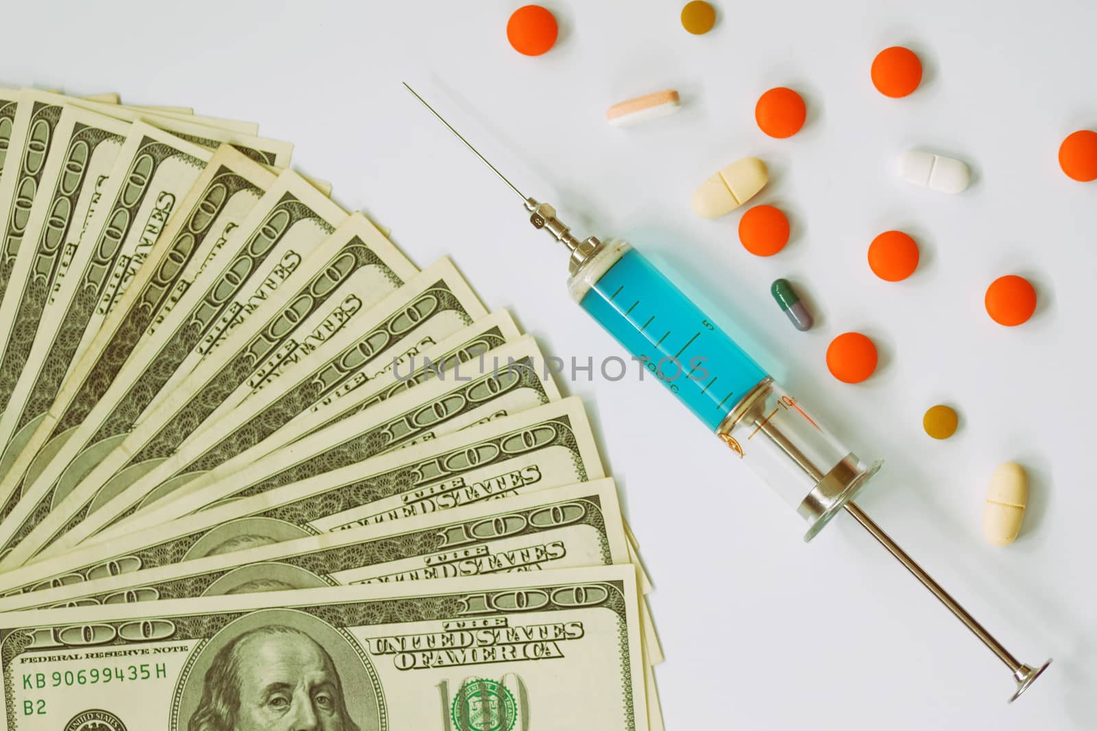 expensive medicine and healthcare, injection needle, pills and banknotes