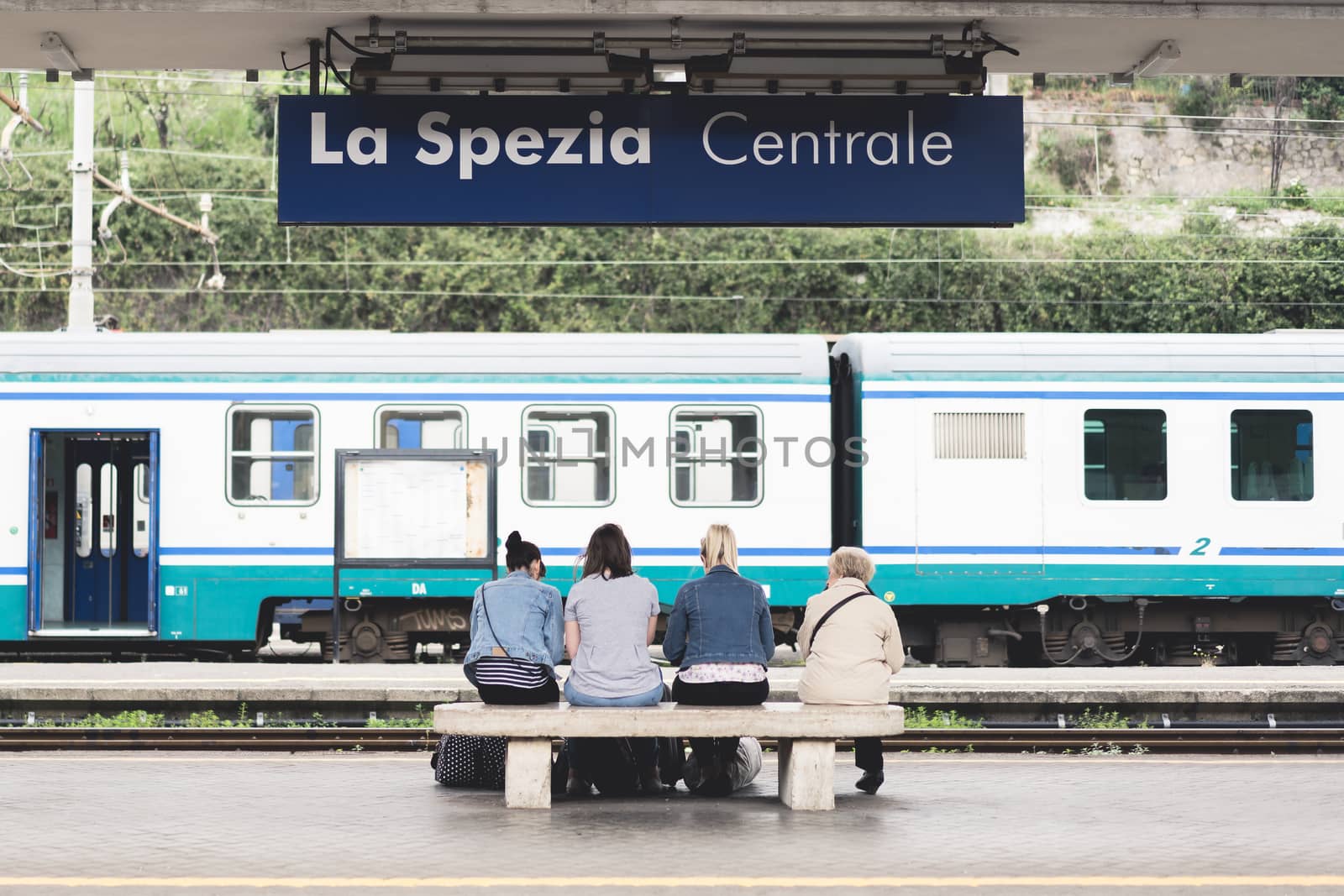 La Spezia, Italy - Apr 8, 2016: Unidentified four European female travelers, young and senior, wait for train at La Spezia Central public train station, visiting Cinque Terre, Italy