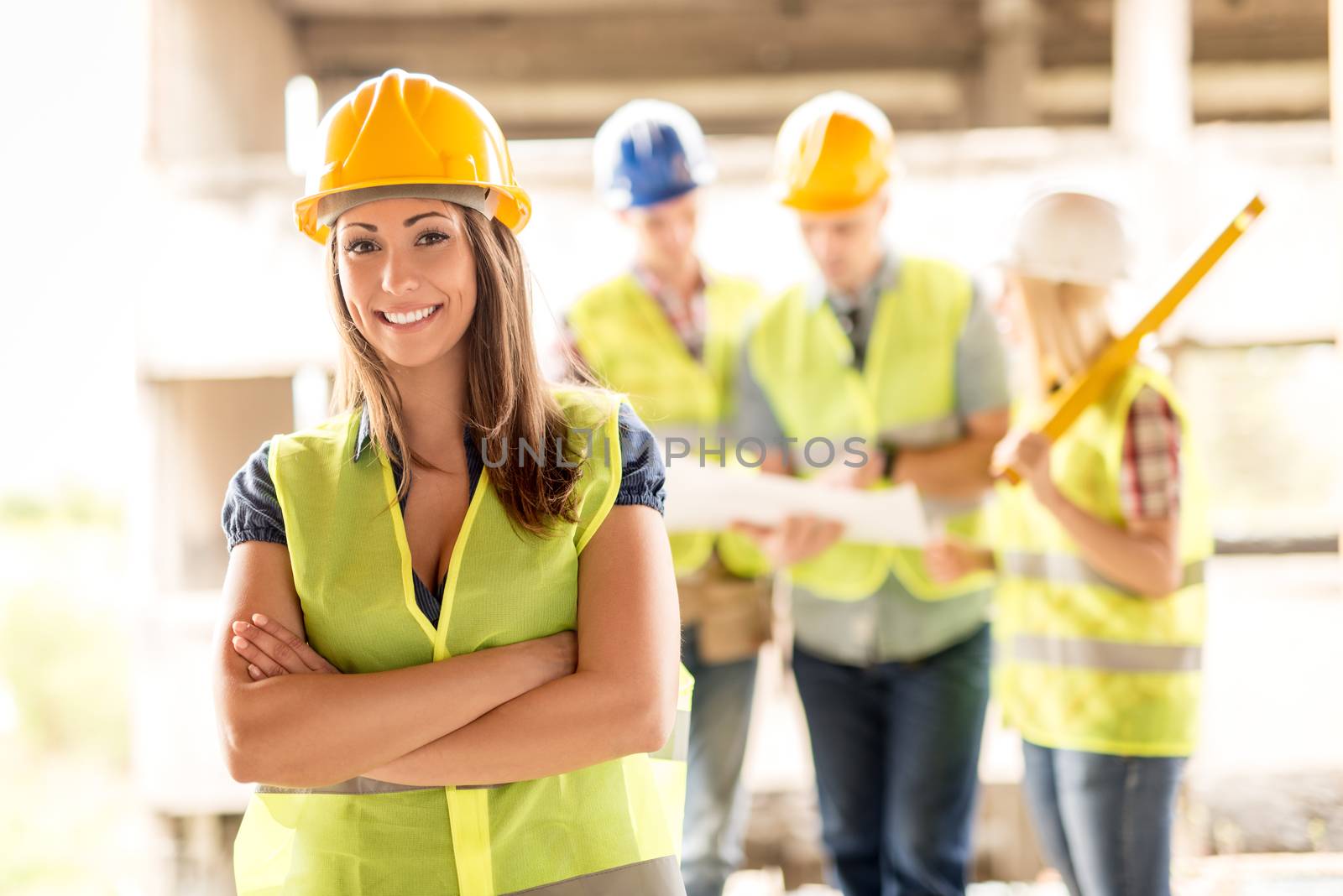 Beautiful young female construction architects at a construction site. She looking at camera.