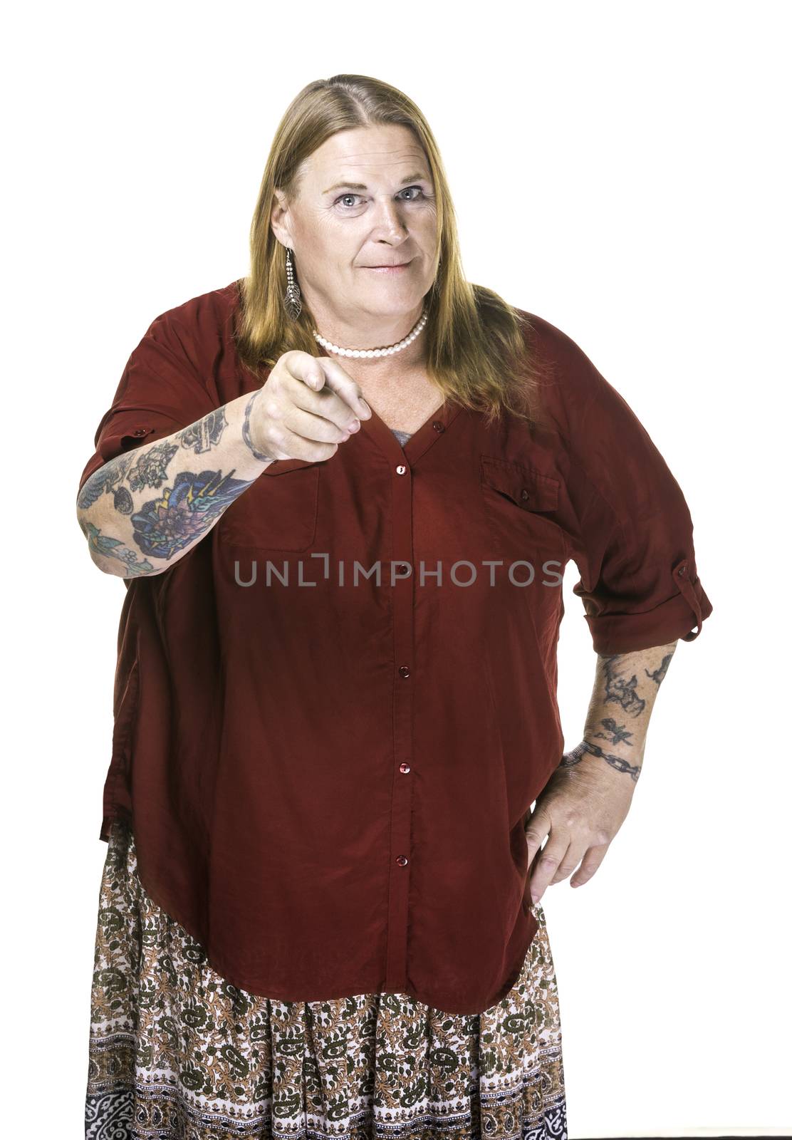 Transgender woman in pearl necklace on white background pointing