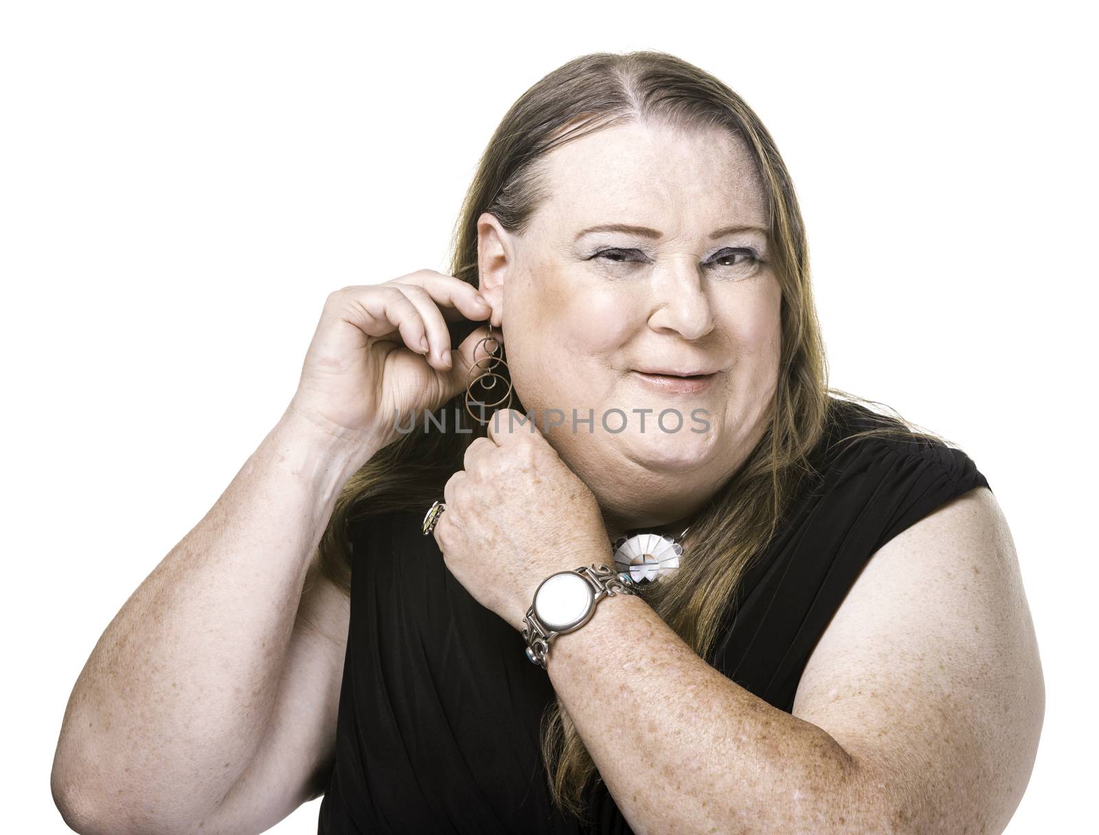 Closeup of transgender woman adjusting earring on white background