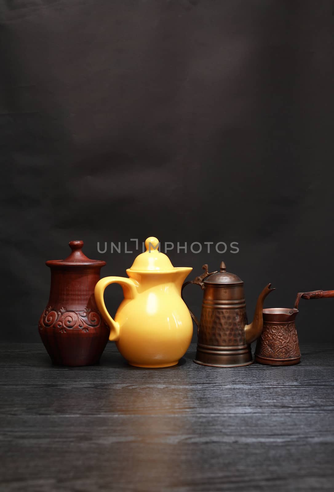 Set of various kitchen dishes on dark background