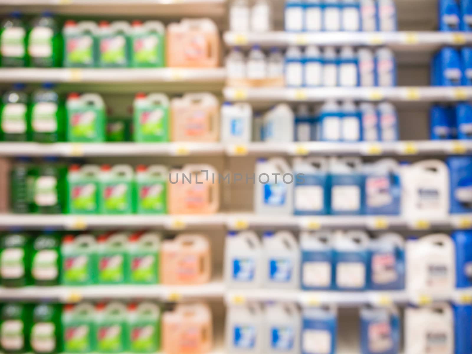 Blurred motor oil on shelves in supermarket by fascinadora
