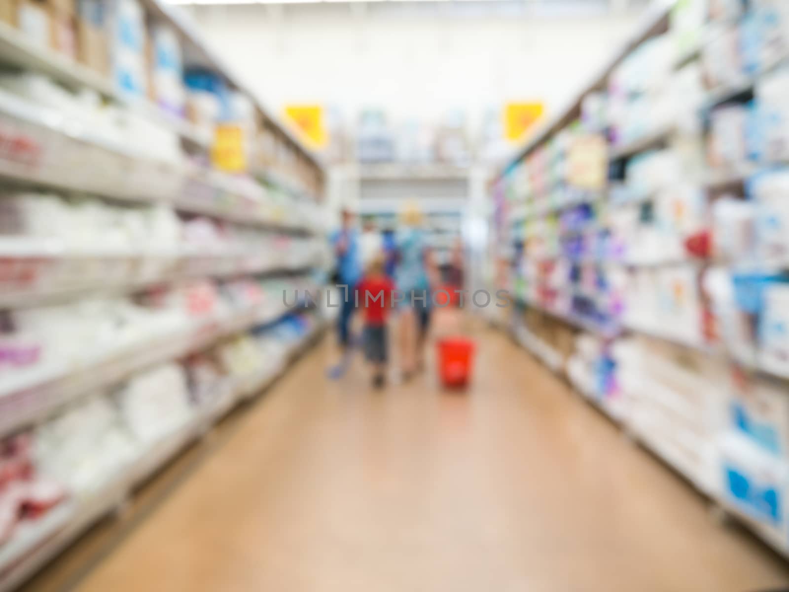 Abstract blurred supermarket aisle with unrecognizable customers as background