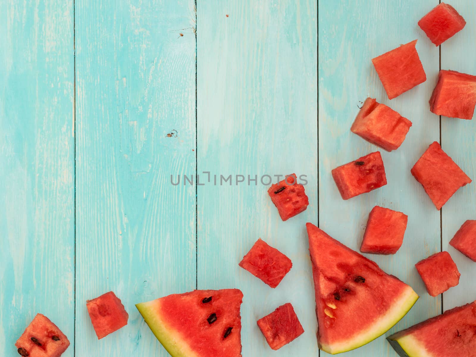 Top view of watermelon pieces on blue wooden table with copyspace. Flat lay