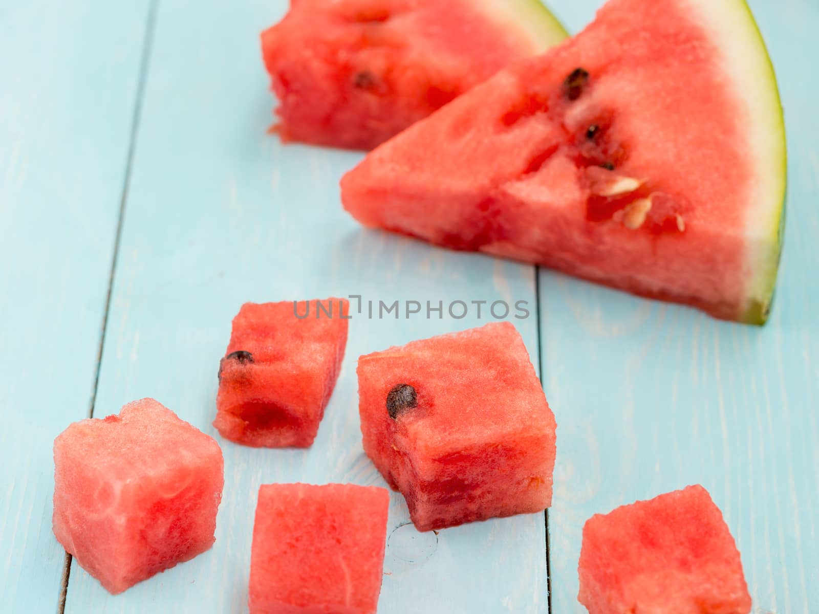 Pieces of watermelon on blue wooden background
