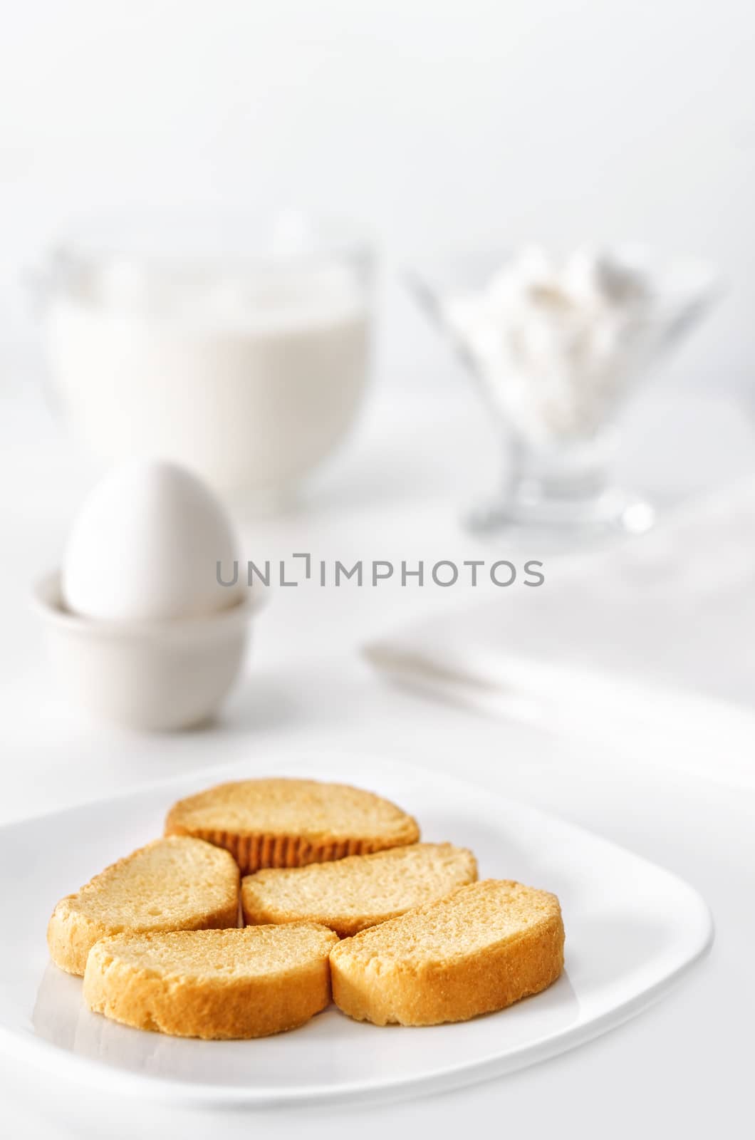 Breakfast white on white, high key and bokeh. A bowl of crackers, eggs, cheese and milk.