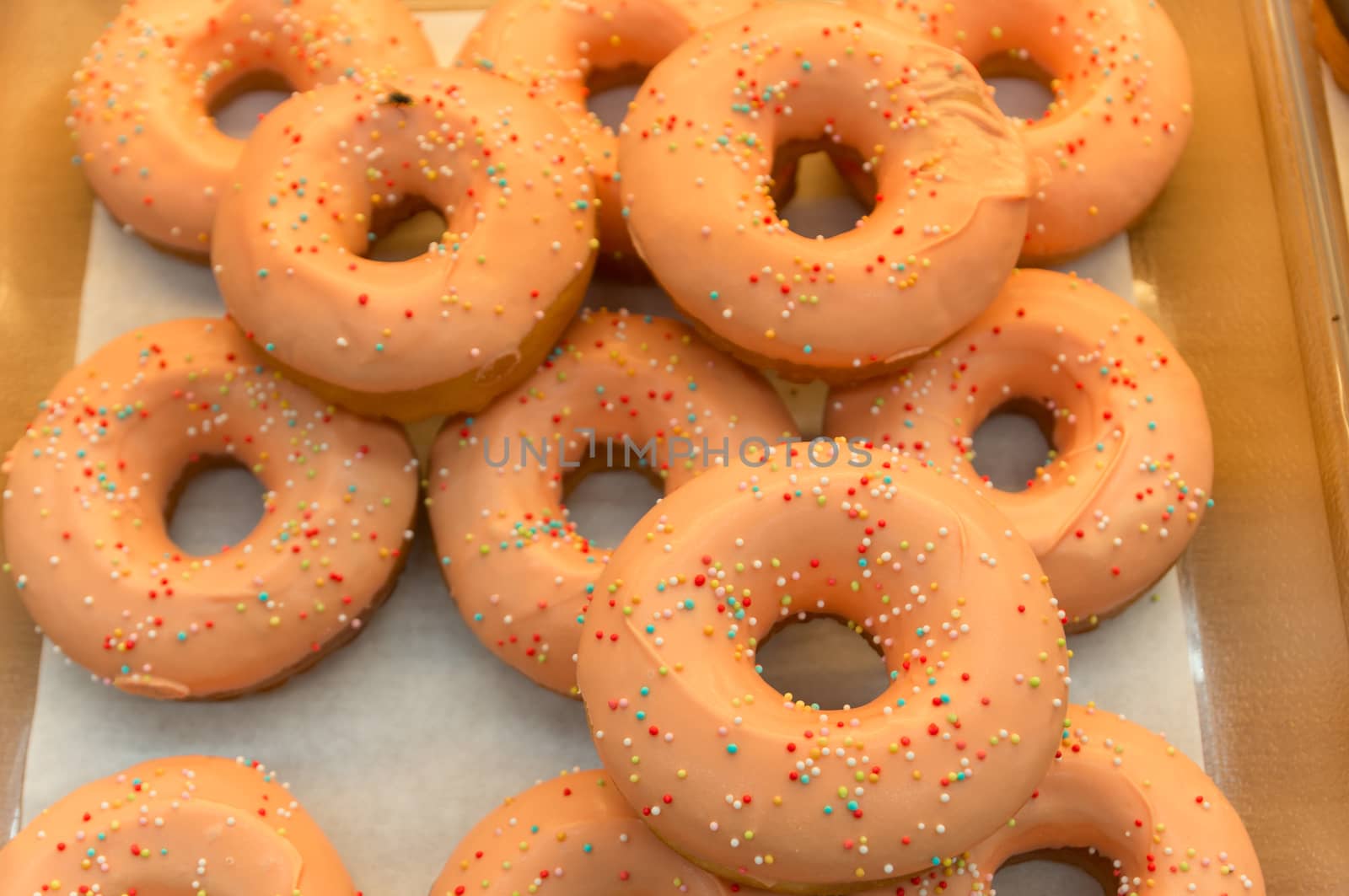 Fresh Donuts with Color Sugar Granules Decorated on shelf. Selective Focus on Big donut