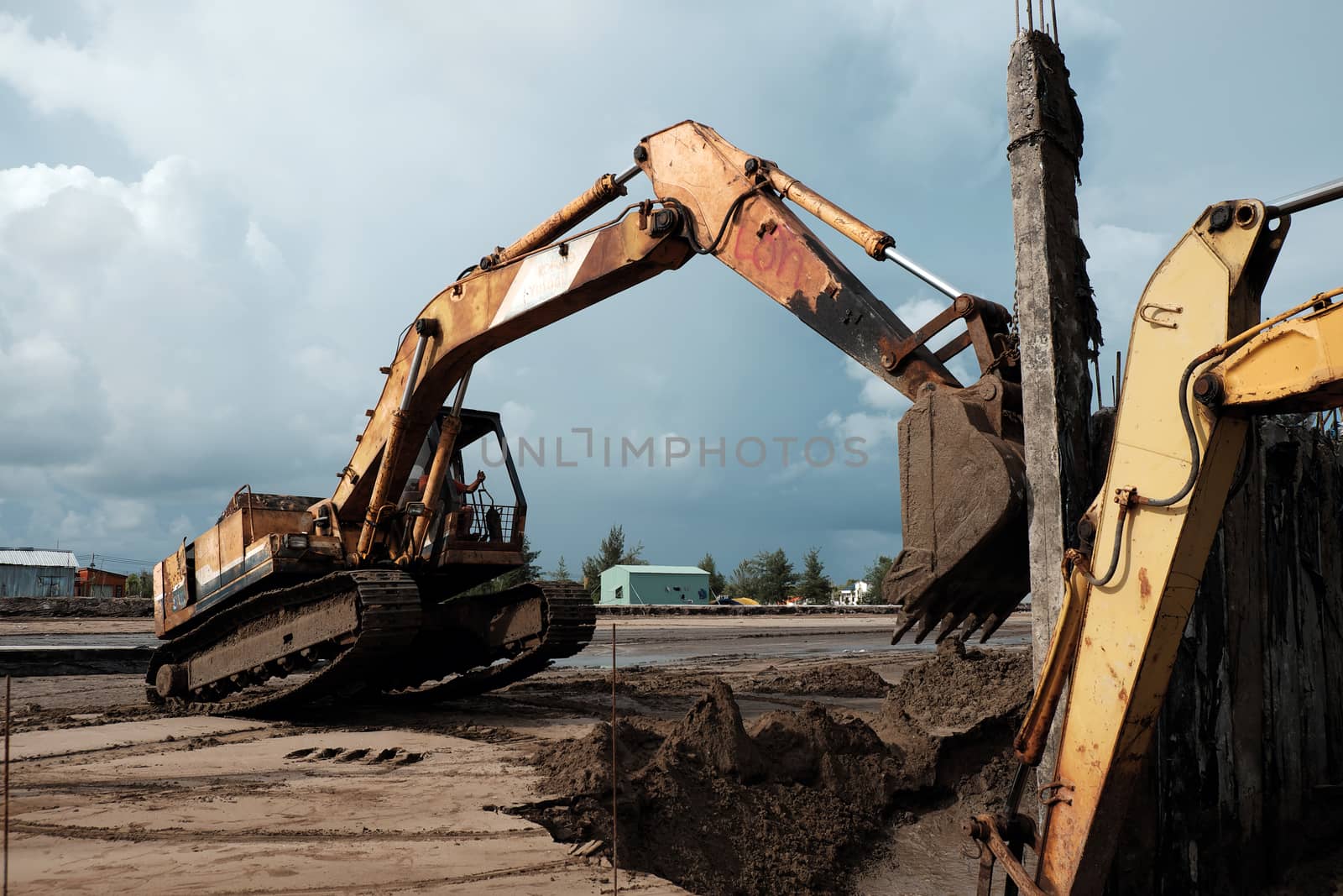 CA MAU, VIET NAM- JULY 16,2016: Vietnamese excavator driver control vehicle to build breakwater at beach to protect seaside from erosion at Camau, Vietnam