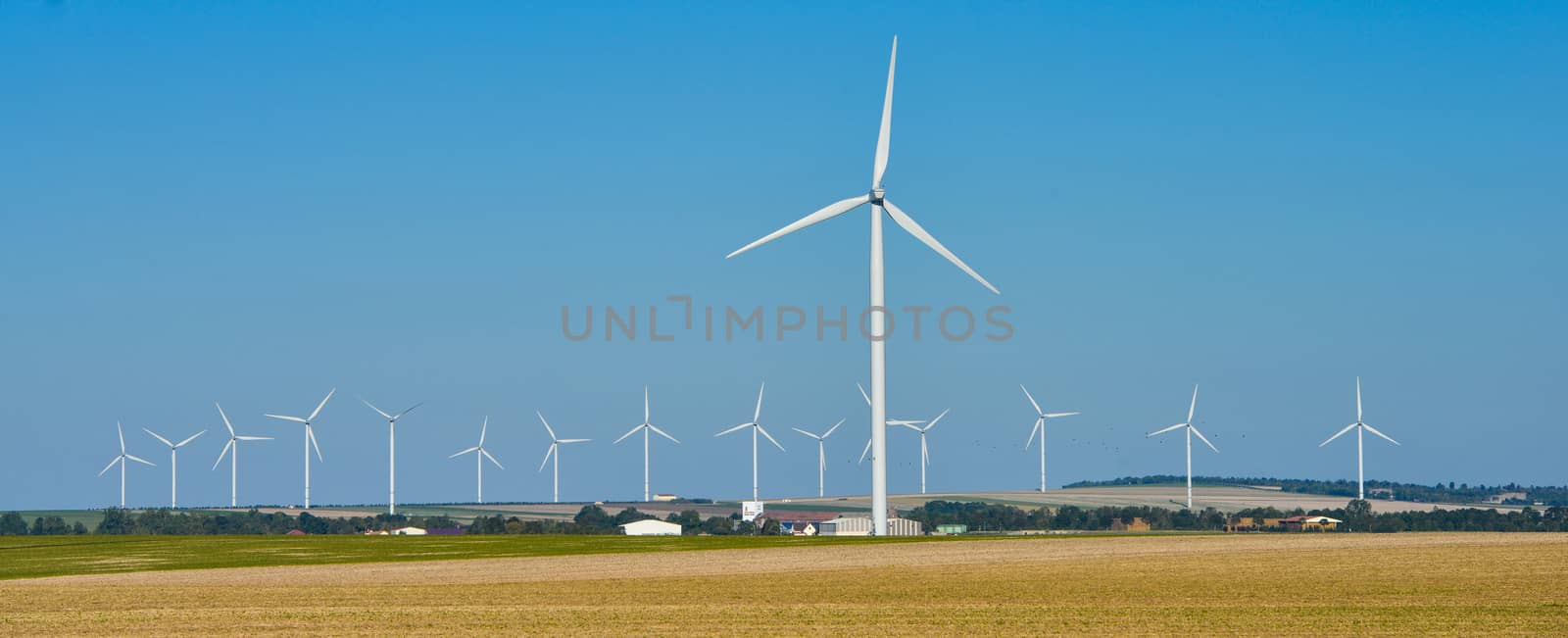 Windmills for electric power production on blue sky, France, Europe