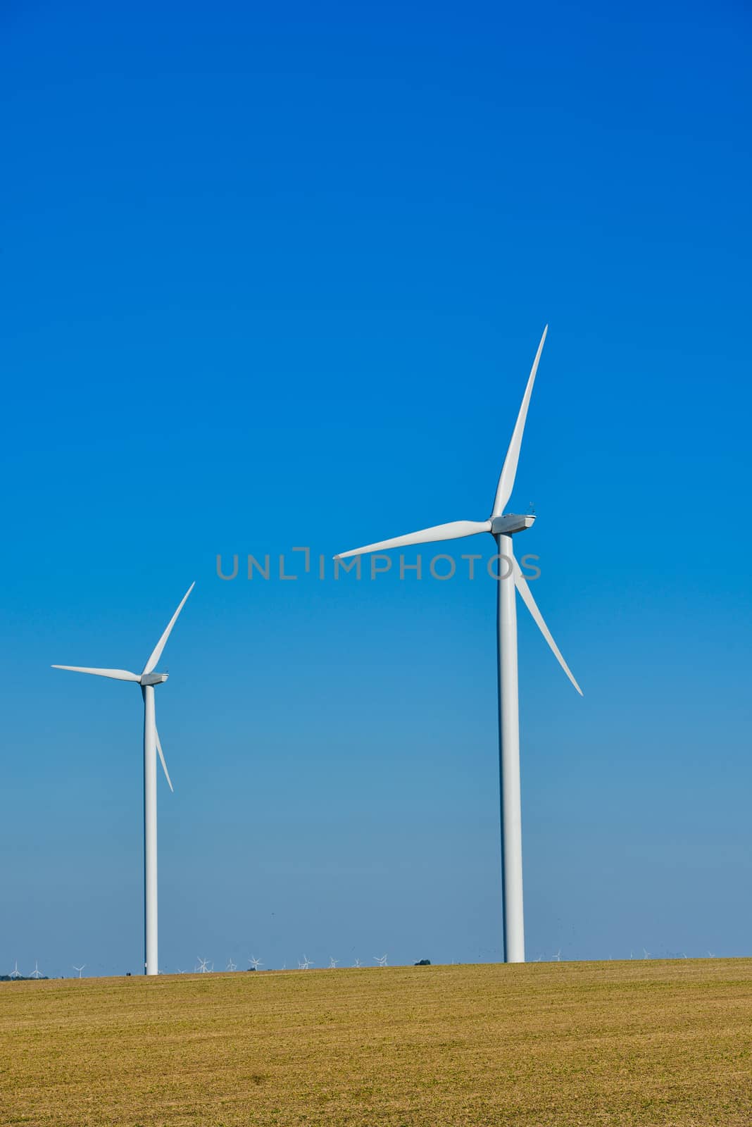Windmills for electric power production on blue sky, France, Europe