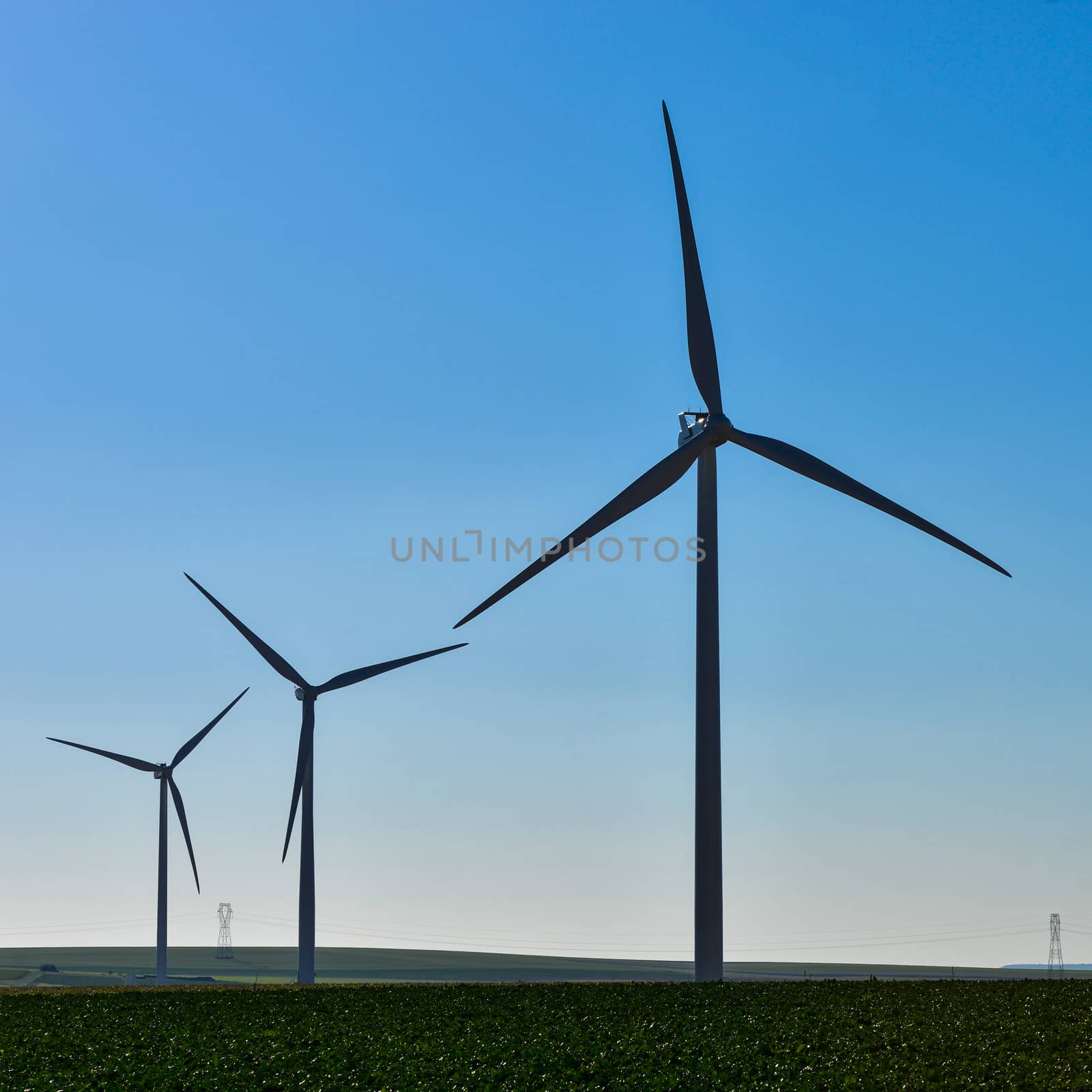 Windmills for electric power production on blue sky, France, Europe