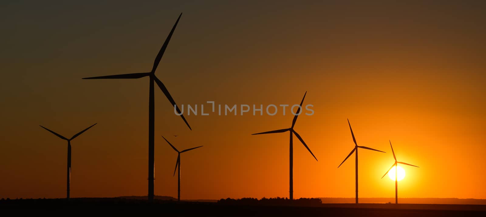 Windwheels and a beautiful sunset seen in rural France, Europe