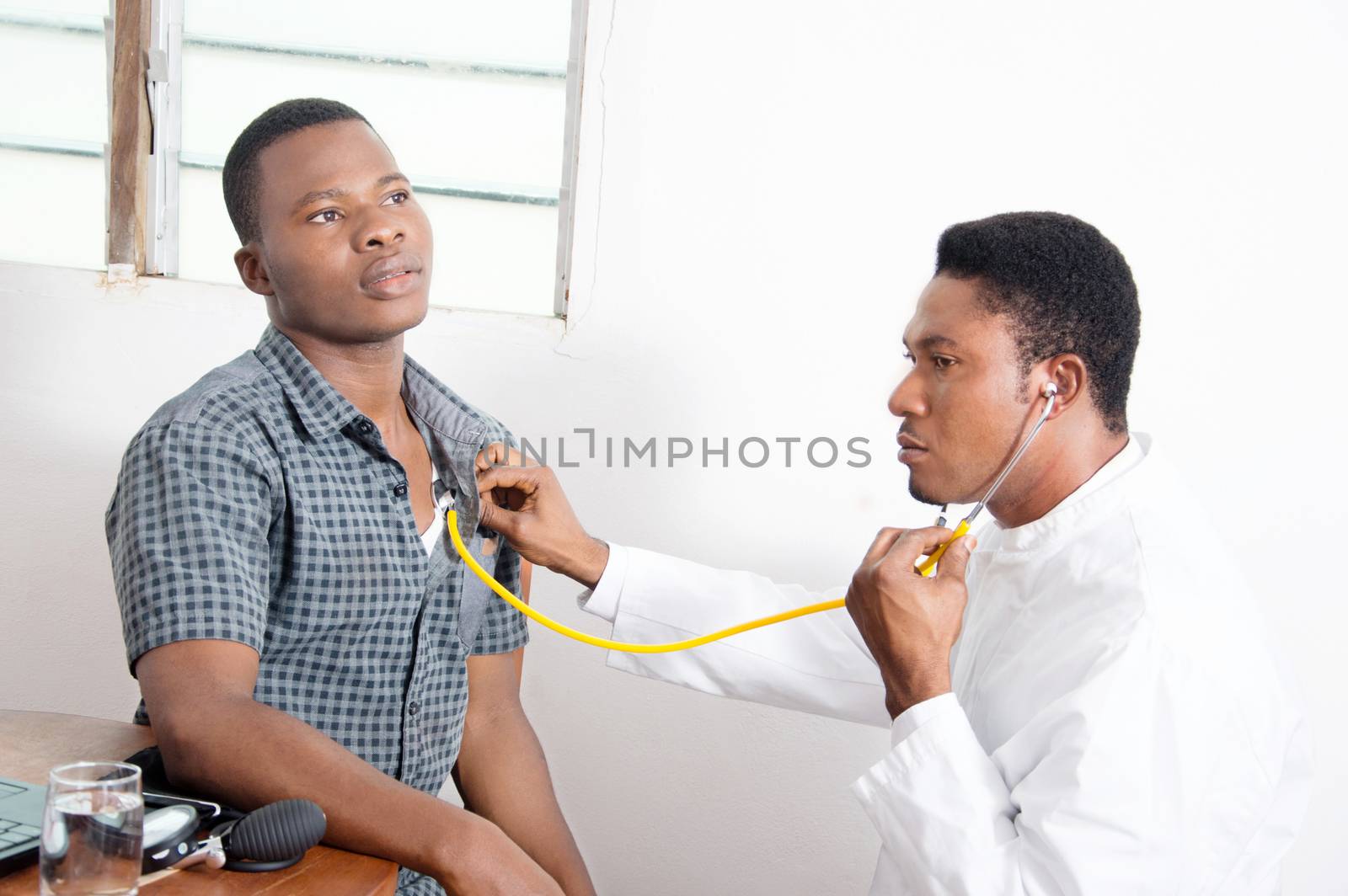 The doctor is listening to the heartbeat of his patient.